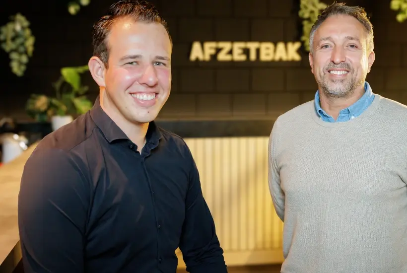 Twee collega's van Afzetbak voor het verlichte Afzetbak-logo