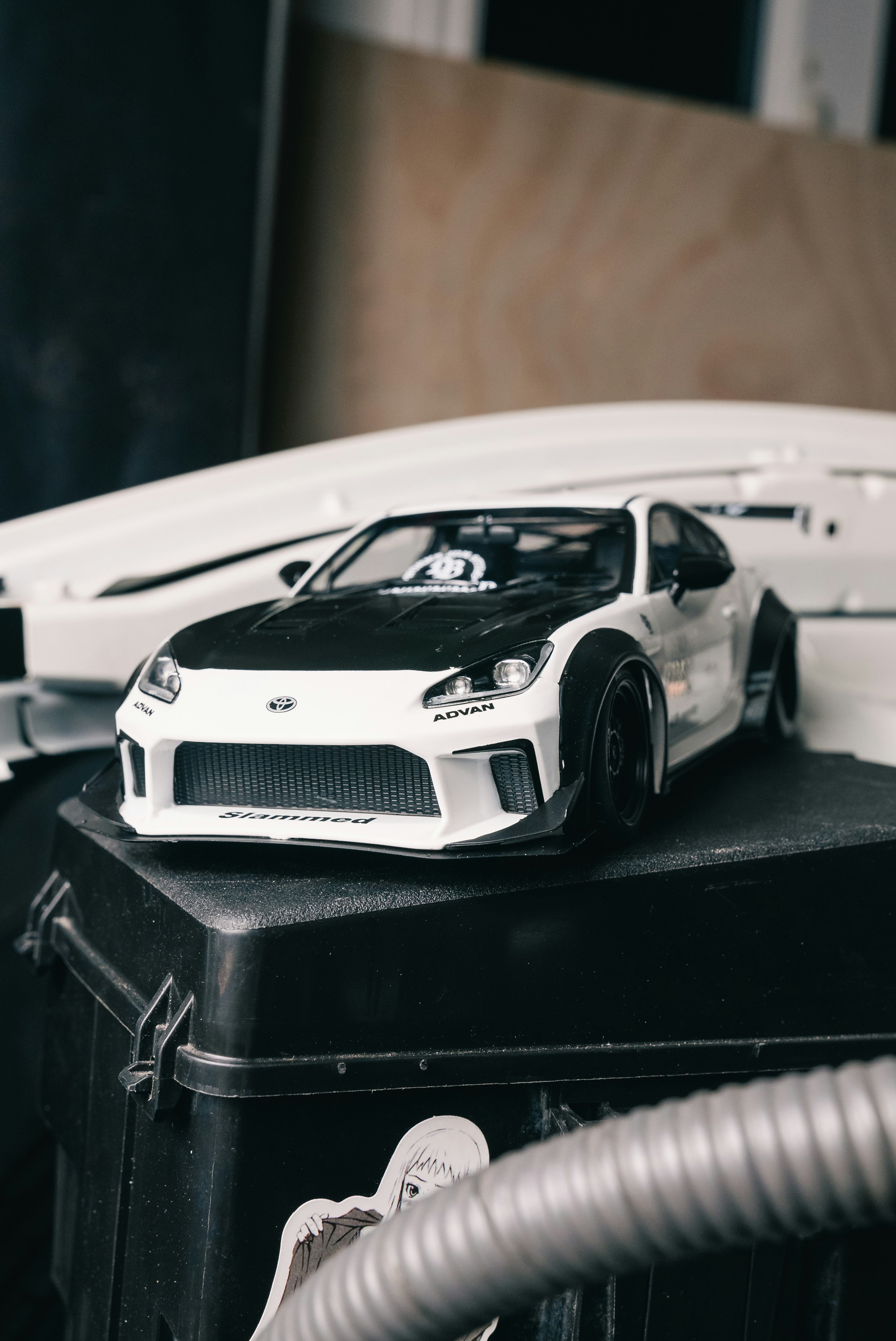 White sports car model with black hood and fender flares