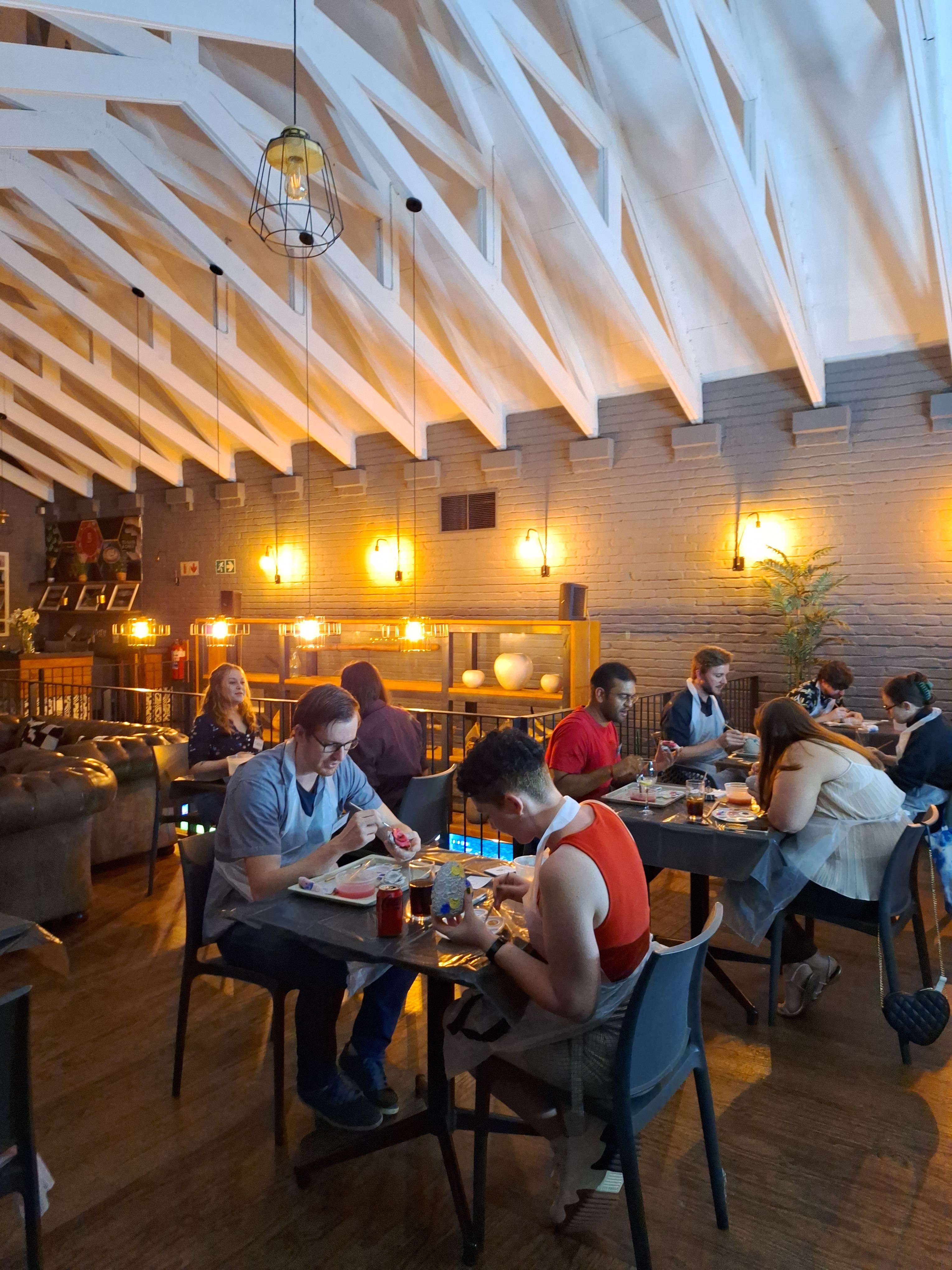 People seated in pairs paiting and talking