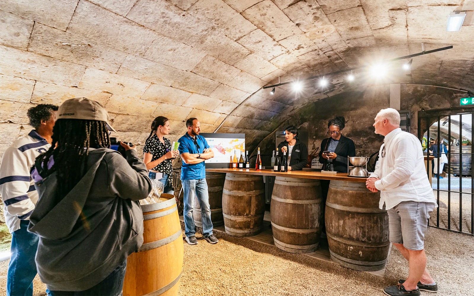 Wine tasting in a Loire Valley castle cellar with a group of people.