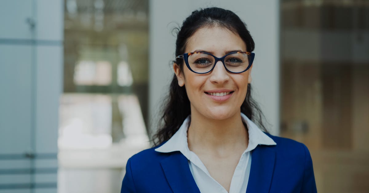 Portrait of a confident businesswoman in a blue suit standing indoors.