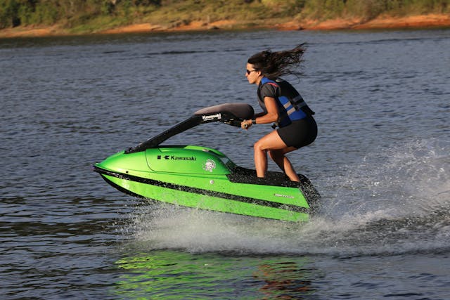 Woman cruising thrugh the open waters while riding a Kawasaki jet ski for beginners.