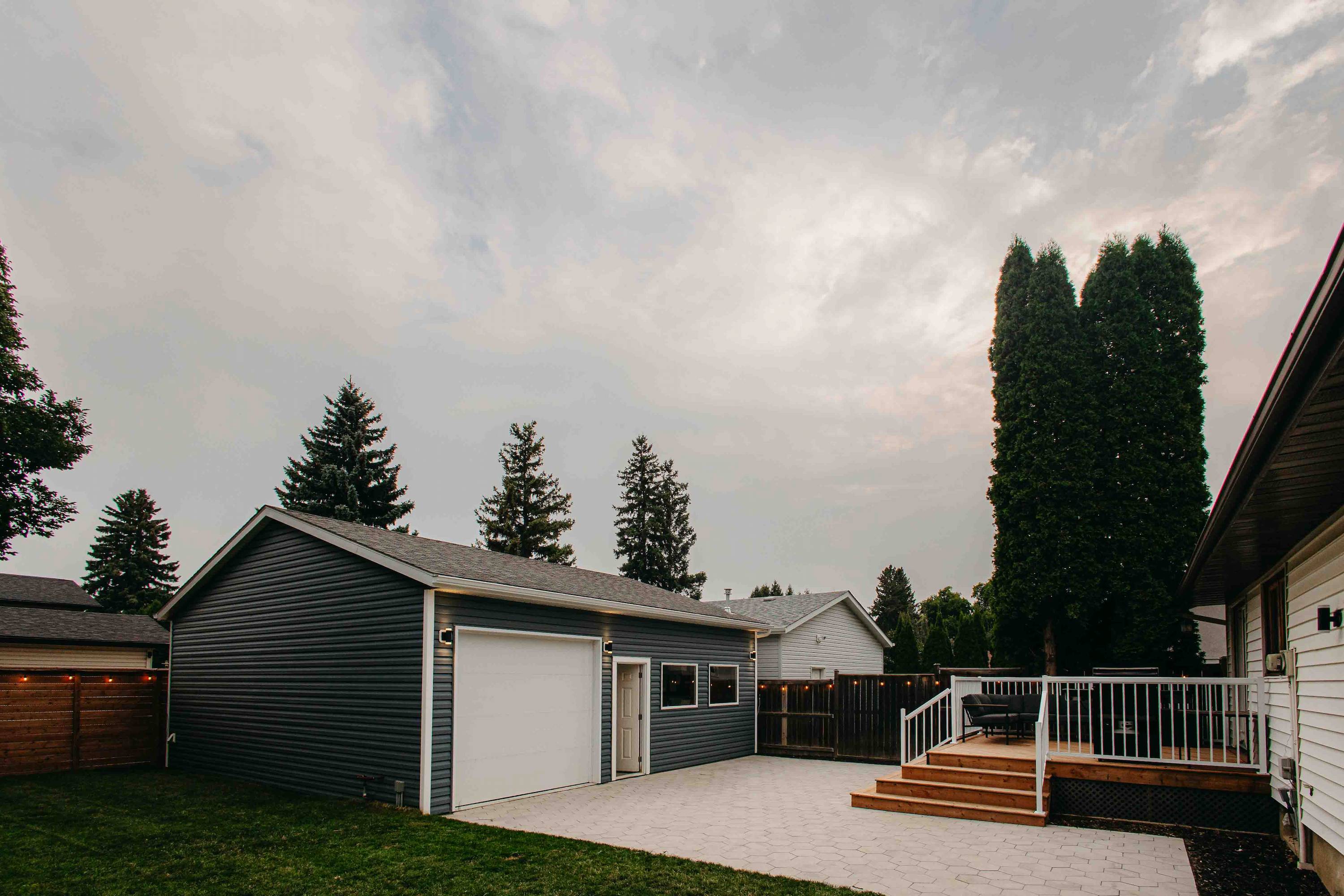 A Saskatoon Backyard after renovation showcasing a full shot of the garage and patio