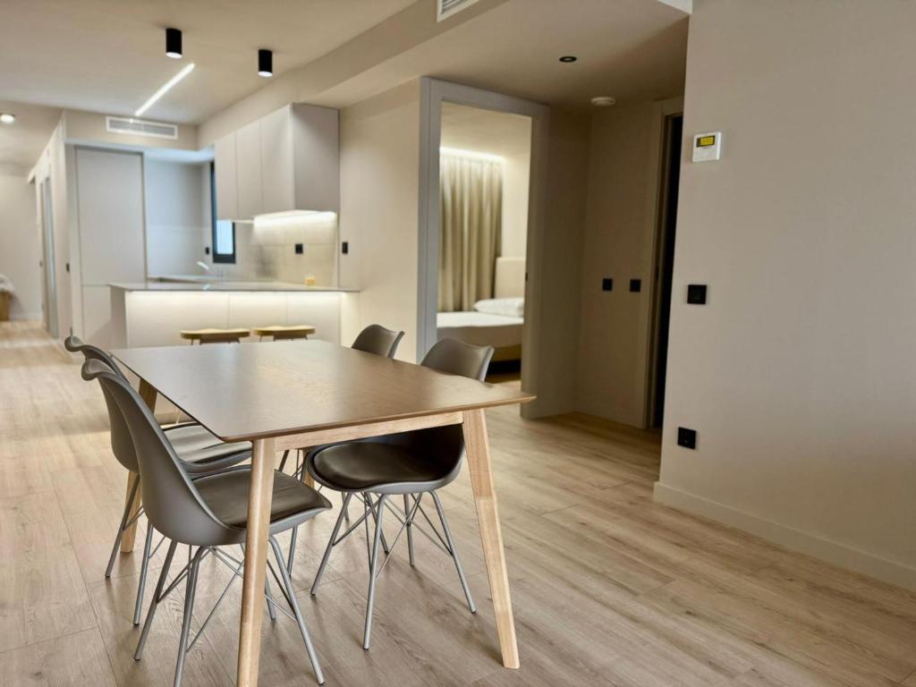 Sant Carles 52: Dining area with gray chairs, wood flooring and a white kitchen