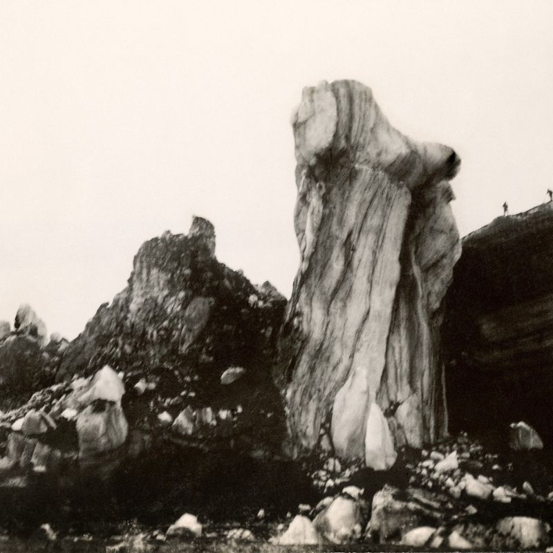Historical photograph of towering icebergs deposited by Katla’s 1918 flood, with two tiny figures on the formation at the upper right.
