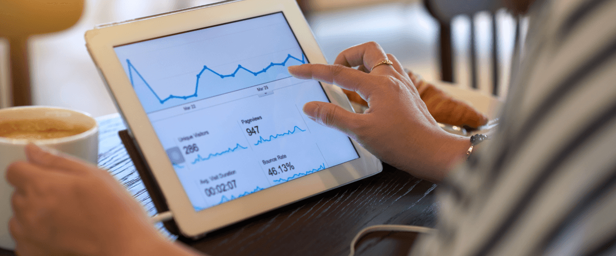 A person analyzing a website analytics dashboard on a tablet, illustrating how videos can reduce bounce rates and increase website engagement.