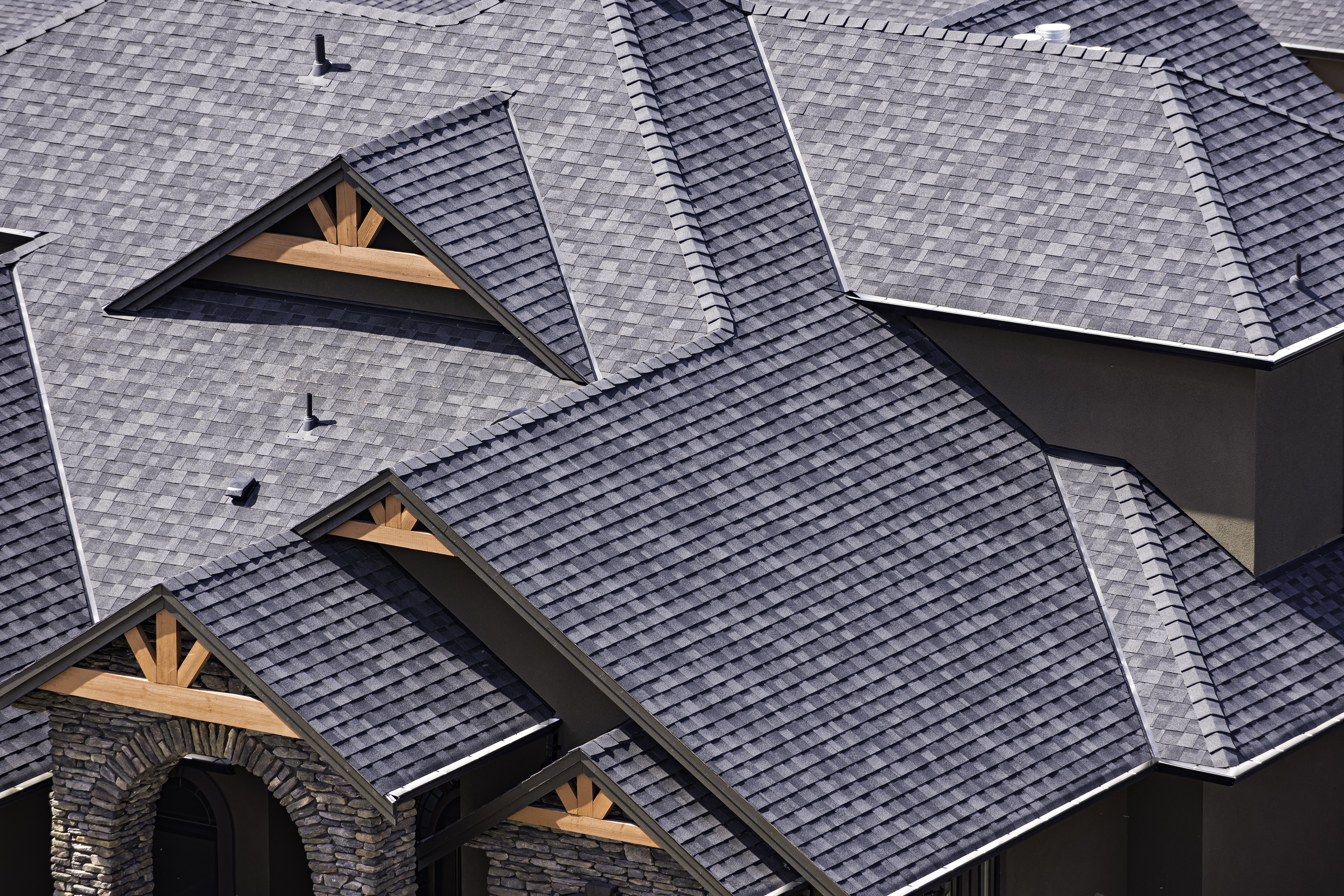 Asphalt shingle roofing on modern house with gable design.