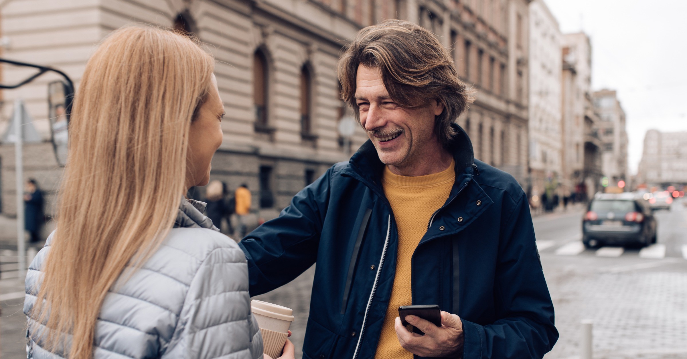 En mann kommer med åpne armer mot en kvinne, klar til å gi en klem.
