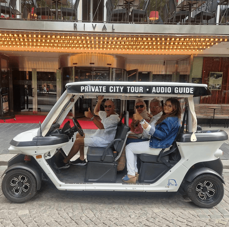 Tourists exploring Stockholm during private electric sightseeing cart tour