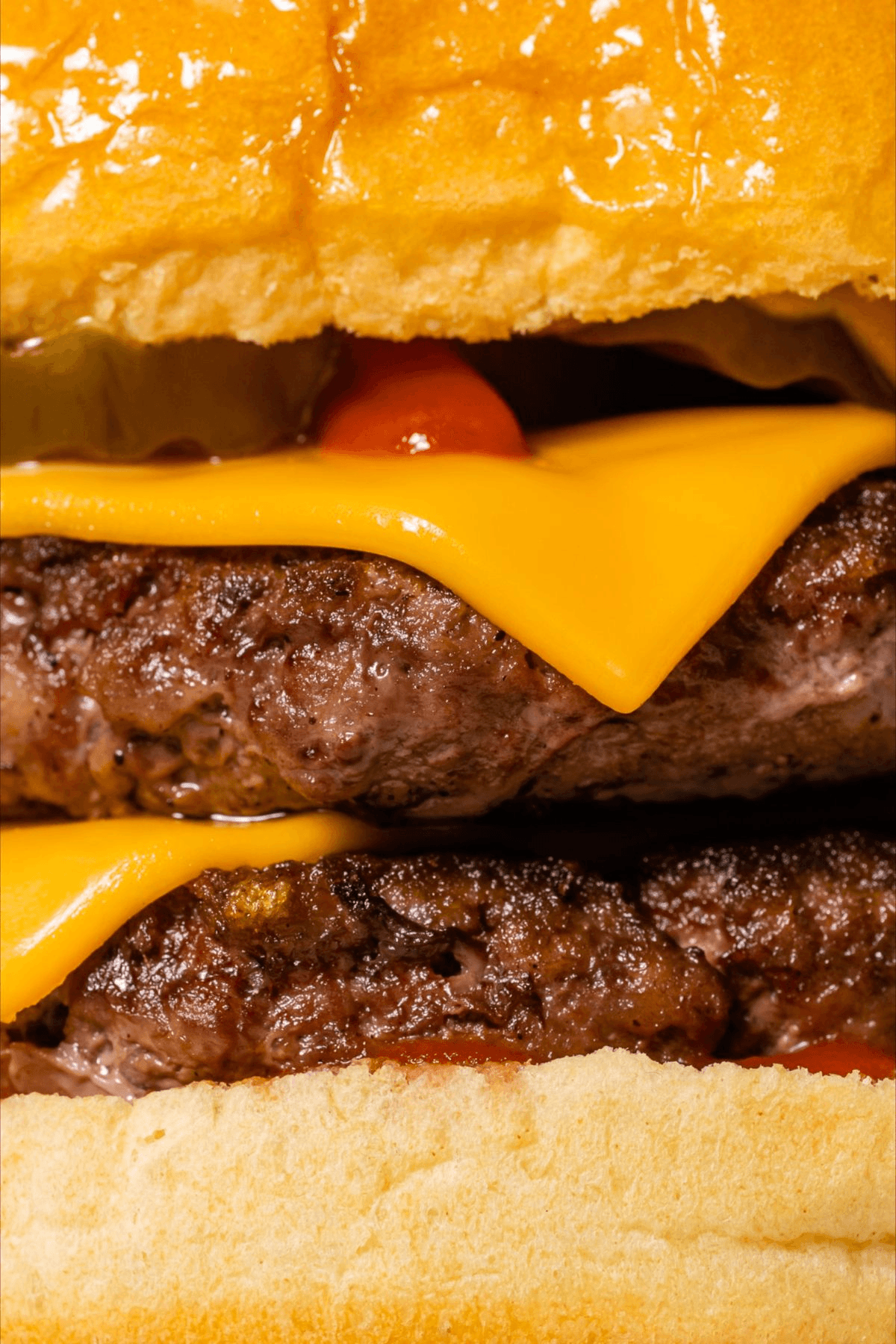 Close-up view of a beef burger with cheese and tomato