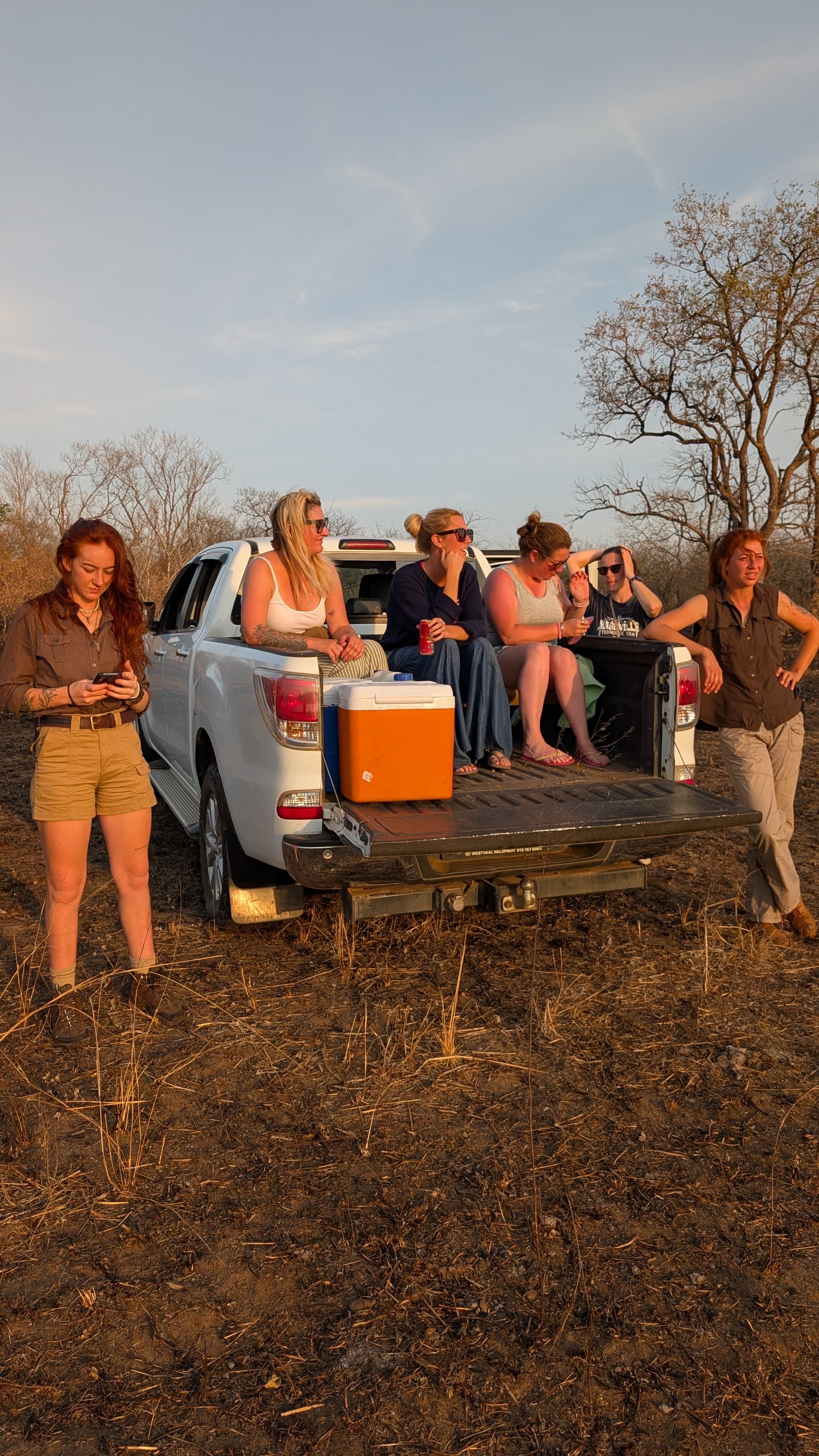 Kilimanjaro Elephant Ride, Arusha National Park, Tanzania – elefant i högt gräs tittar mot kameran, medan fem ryttare till häst på ridsafari i bakgrunden betraktar elefanten i ett grönt och frodigt landskap.