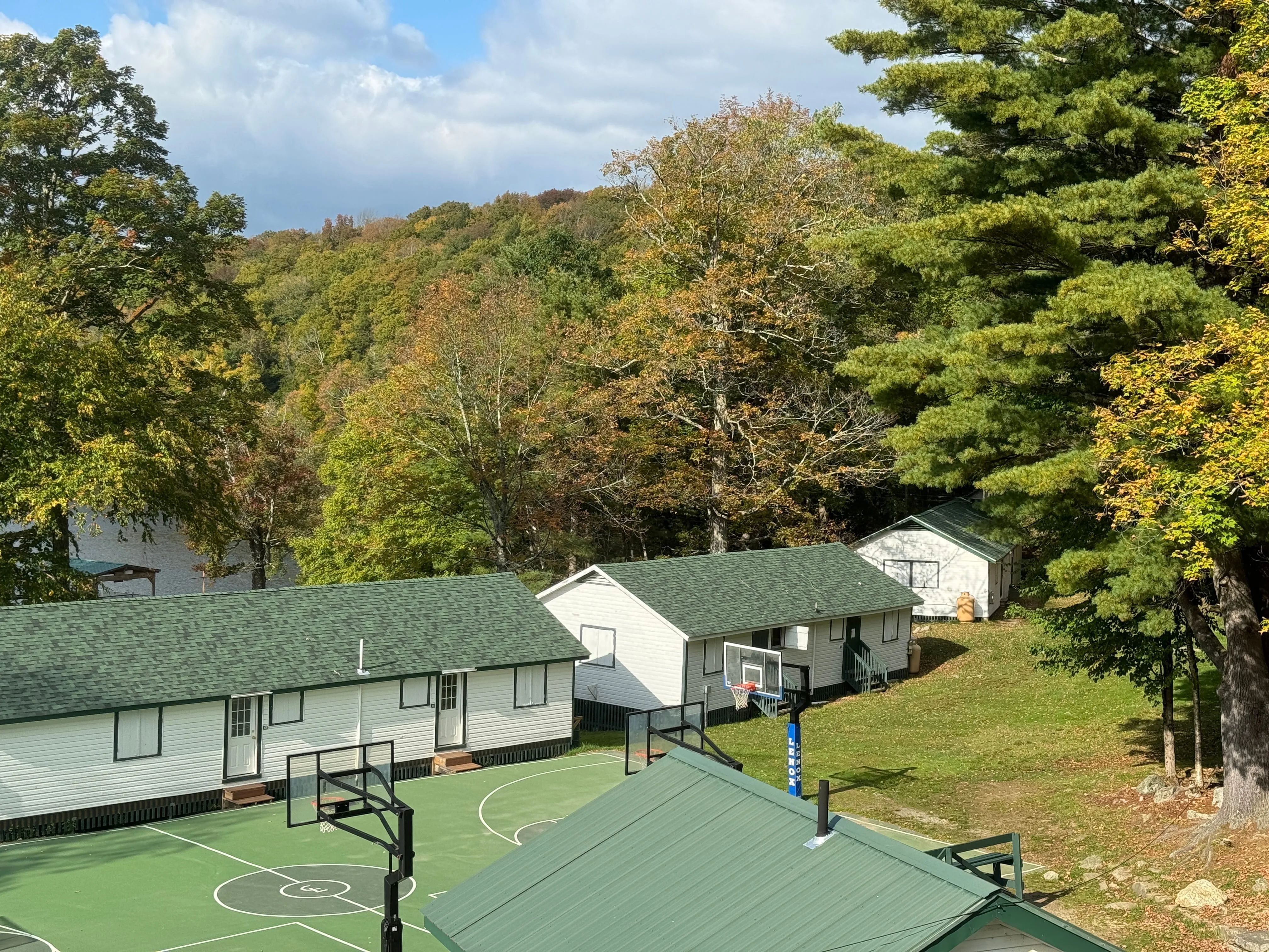 Aerial view of cabins and trees by the lake at Camp Lenox
