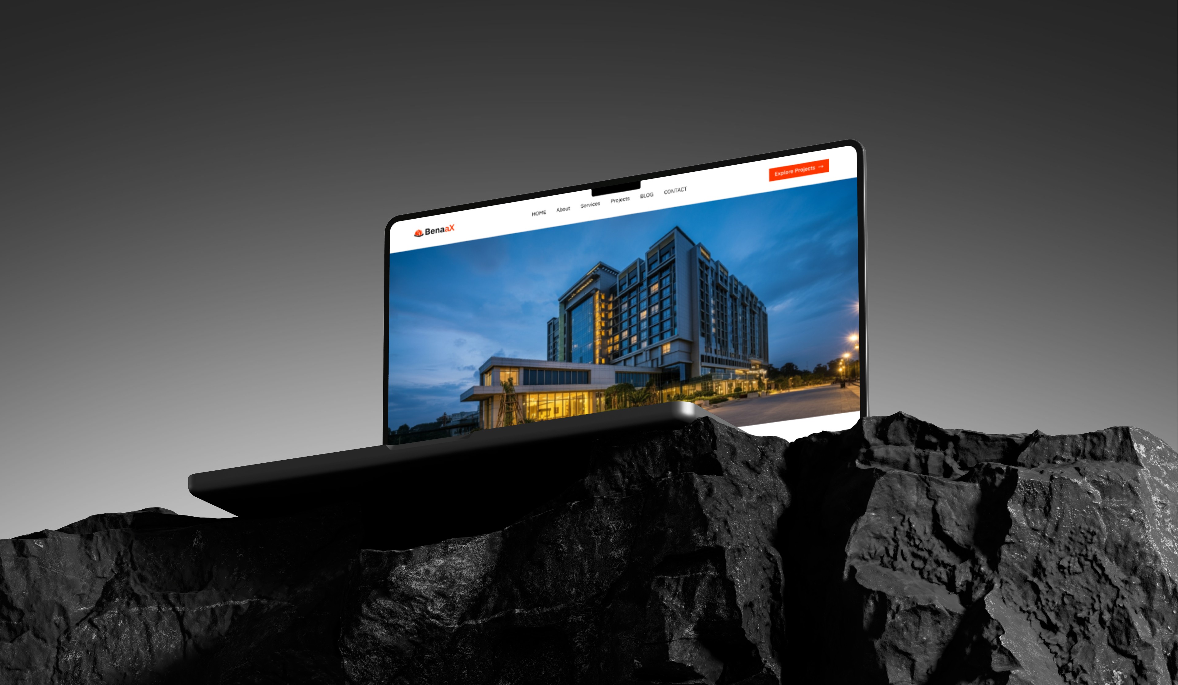 Laptop displaying hotel website on a rock. The website shows a picture of a large, modern hotel at night.