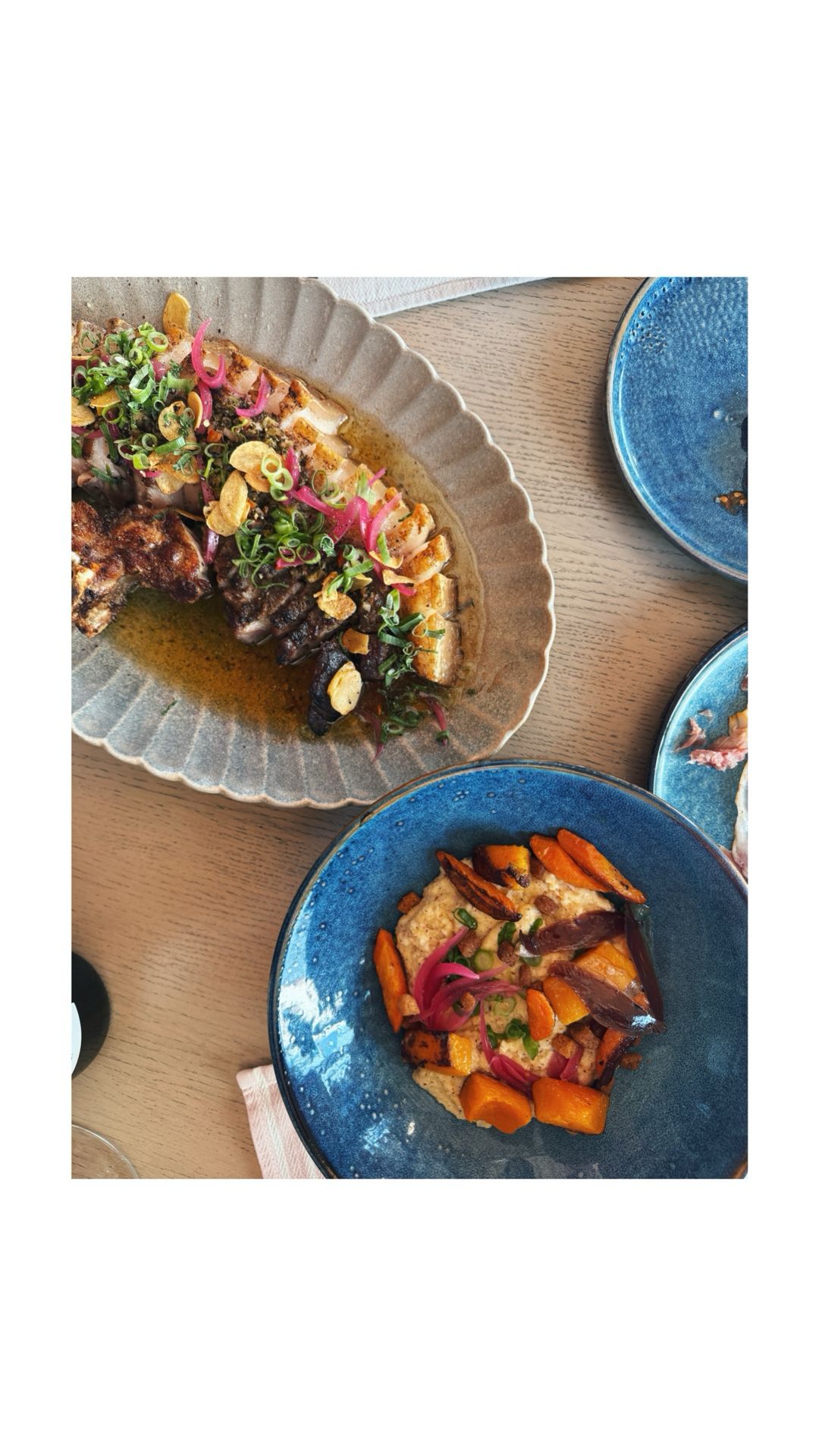 Golfer taking a swing on a sunny day at a coastal golf course. Two other golfers are visible in the background.