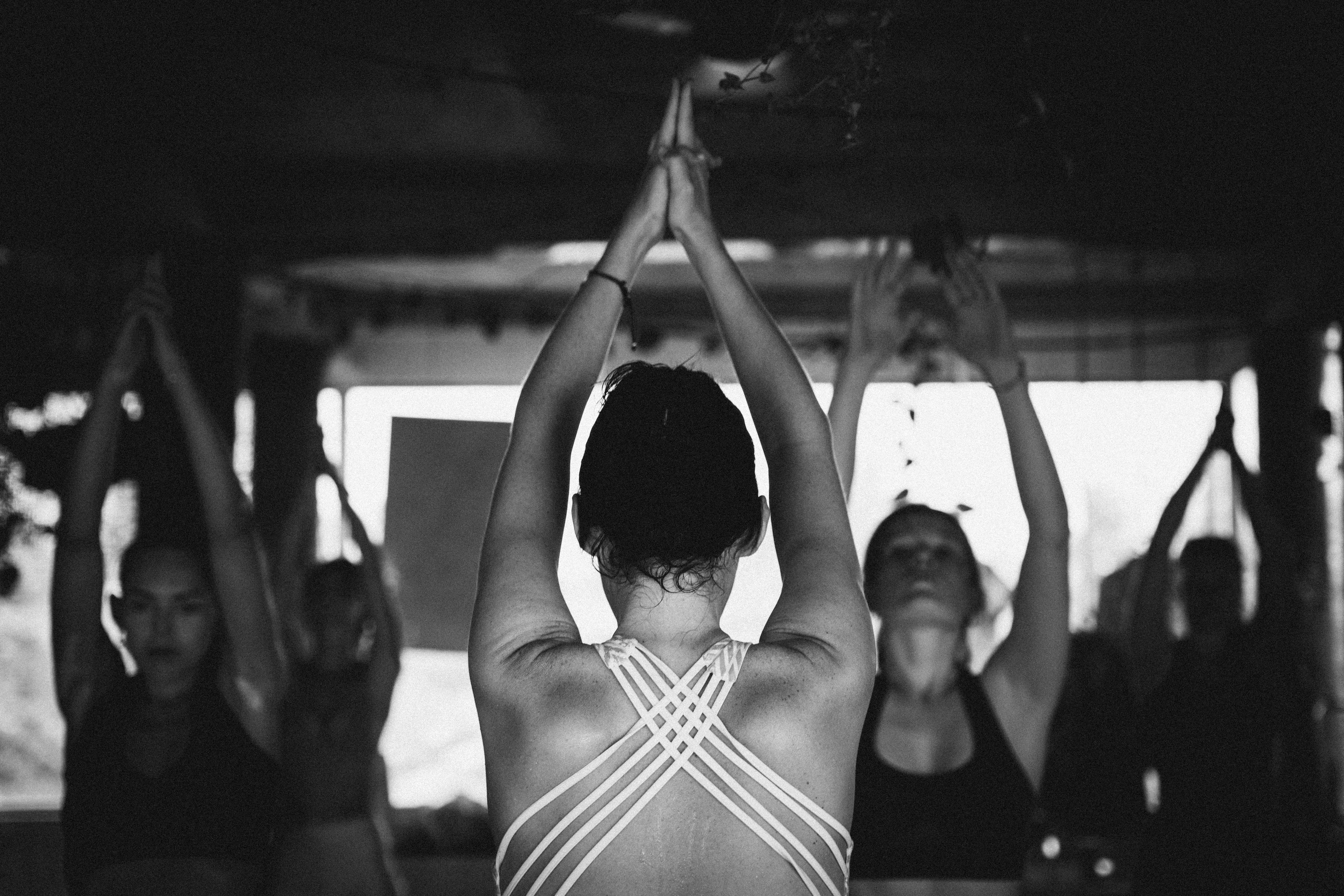 A group of people doing yoga in a dark and hot room.