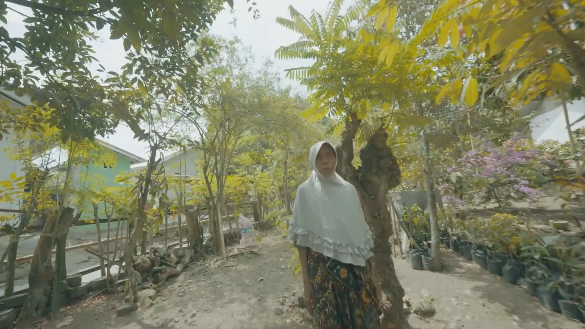 a local woman in Genggelang stares into the camera as it approaches her