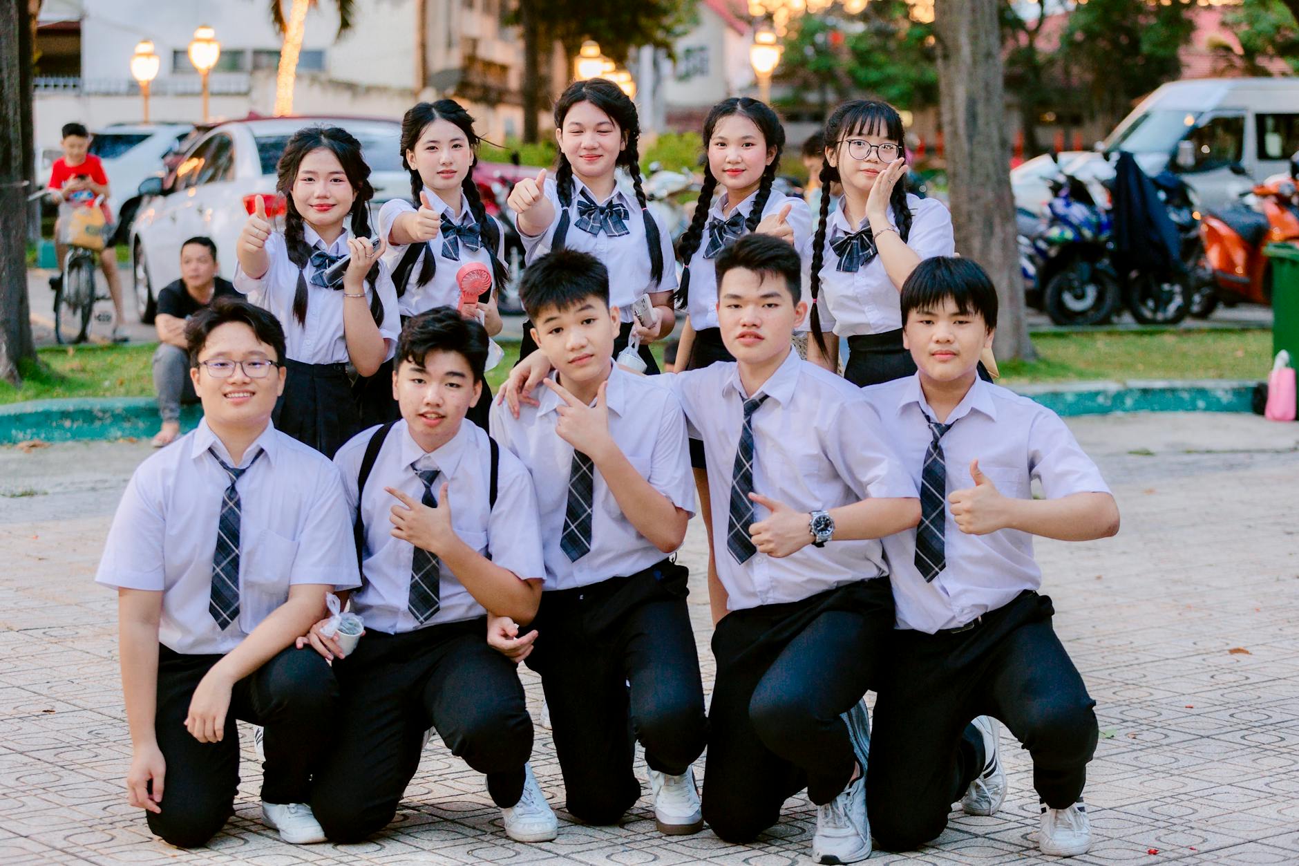 Two high school students of different backgrounds high-fiving while working together on a laptop.