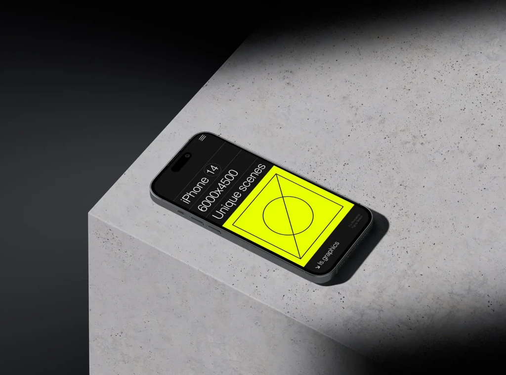 An iPhone with a yellow geometric mockup on its screen is placed on a concrete block, set against a dark background. The contrast between the illuminated screen and the surrounding darkness emphasizes the phone's display.