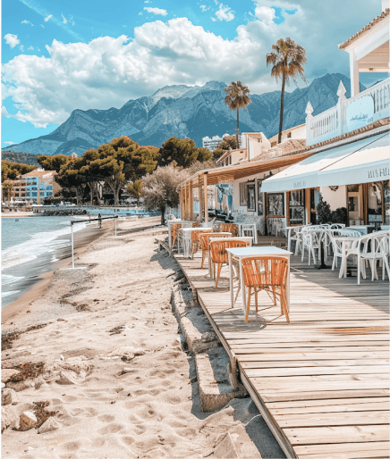 Comfortable bean bags by a pool with palm trees and a beach view.