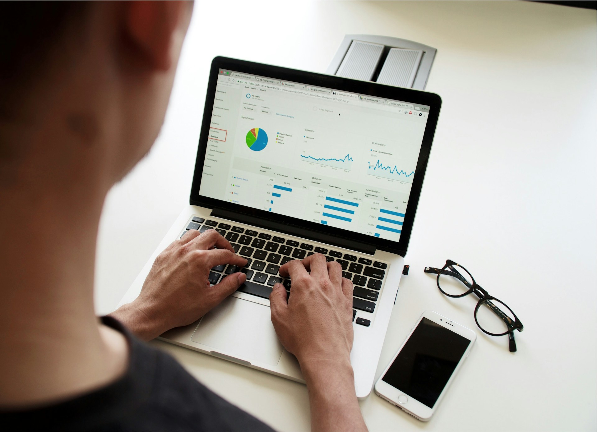 A man typing on a laptop with an analytics tab open.