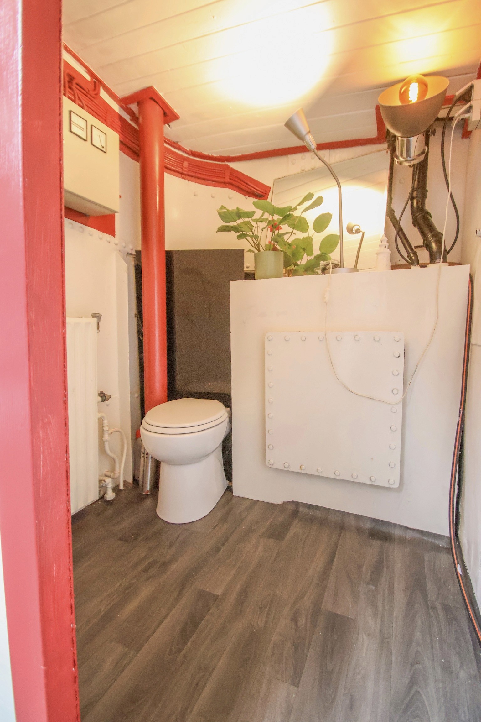 Beige upholstered bed with patterned pillows and ottomans