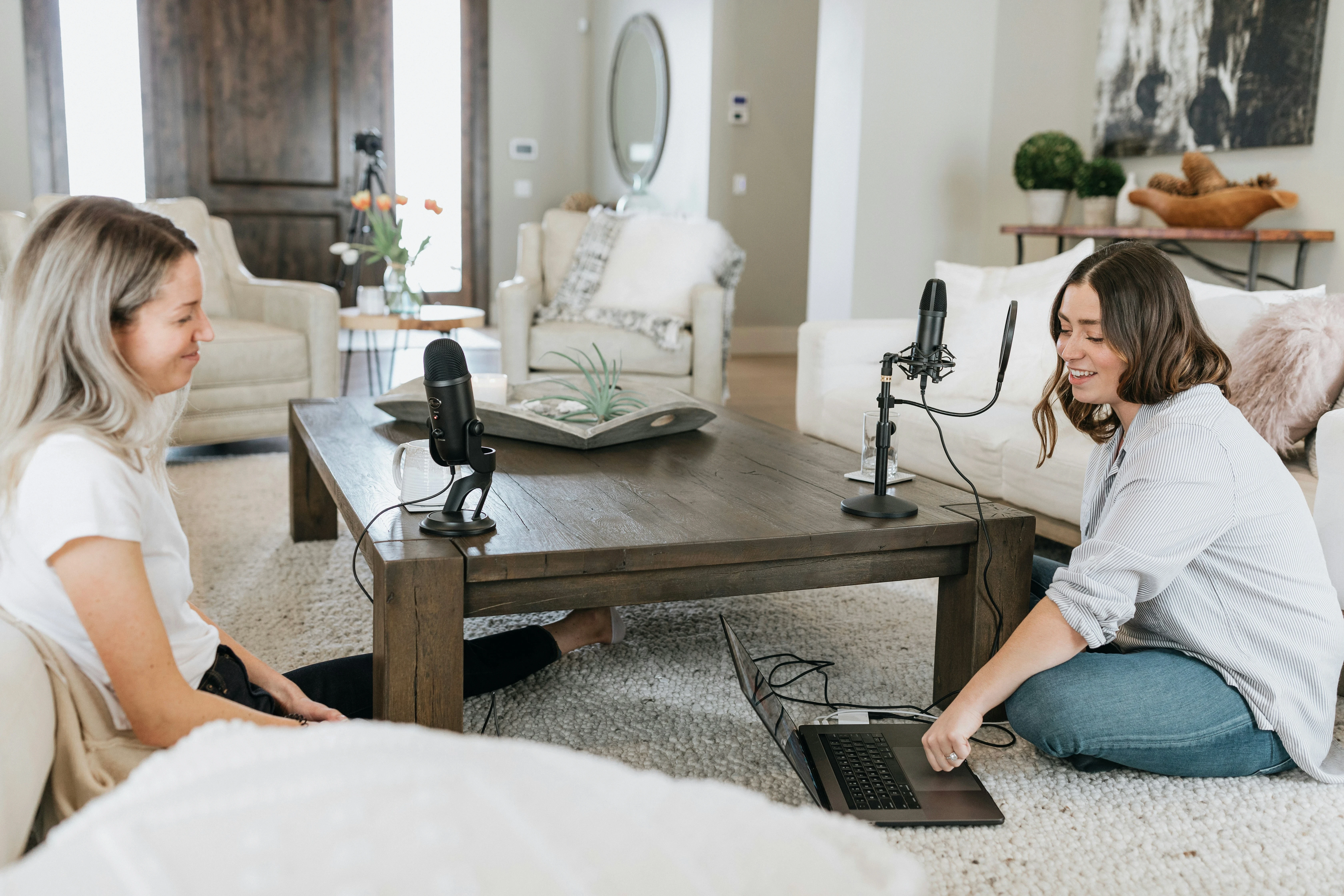 High school students recording a podcast at home for a RISE summer project on digital storytelling, using professional mics and a laptop for audio editing.