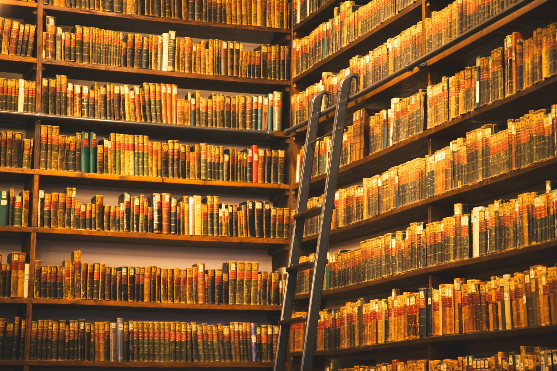 A library shelf filled with modern educational books and a laptop showing the cult of pedagogy website.