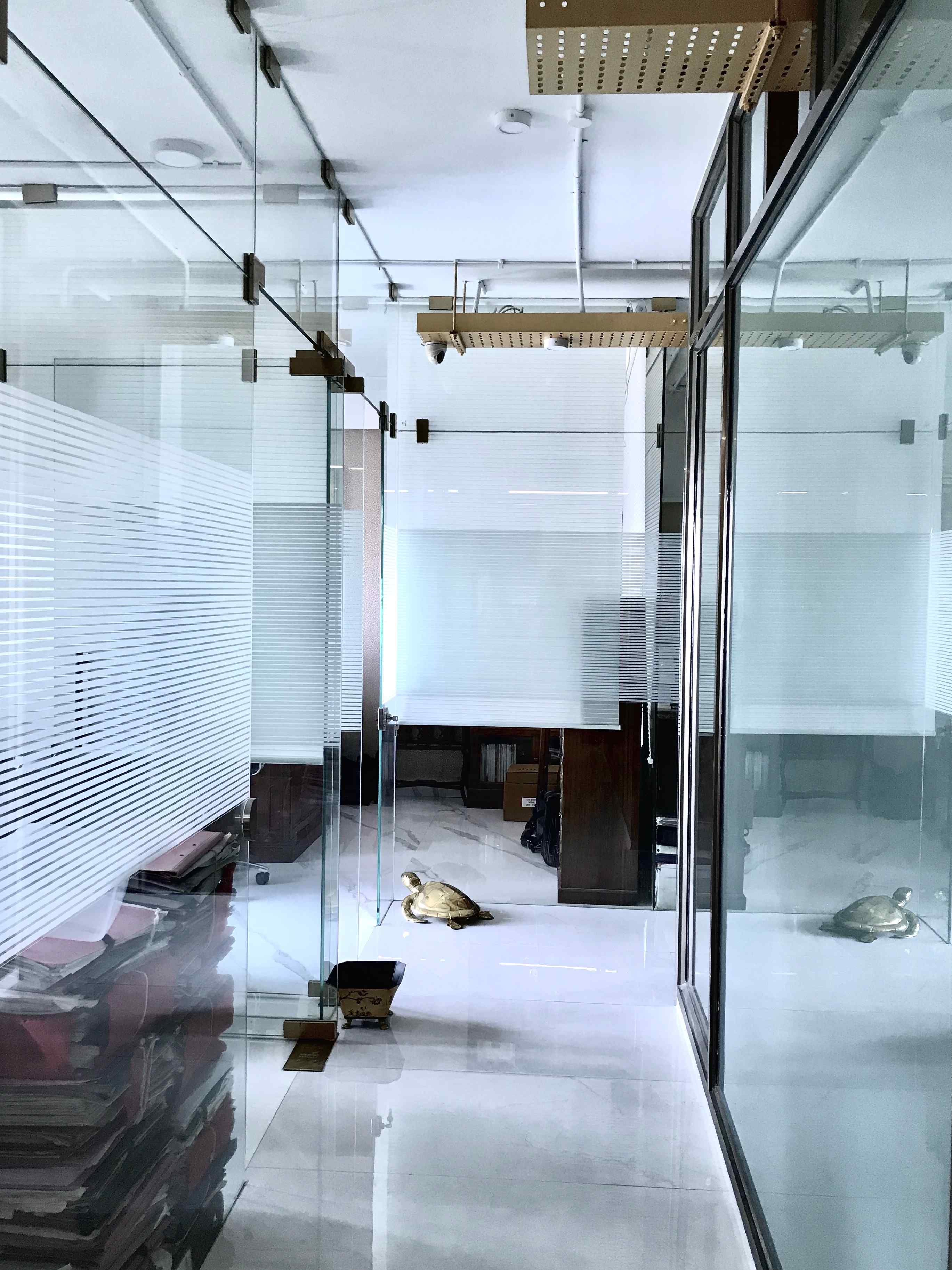 Nature-inspired preschool entrance with sculptural tree partitions and suspended green leaf ceiling panels.
