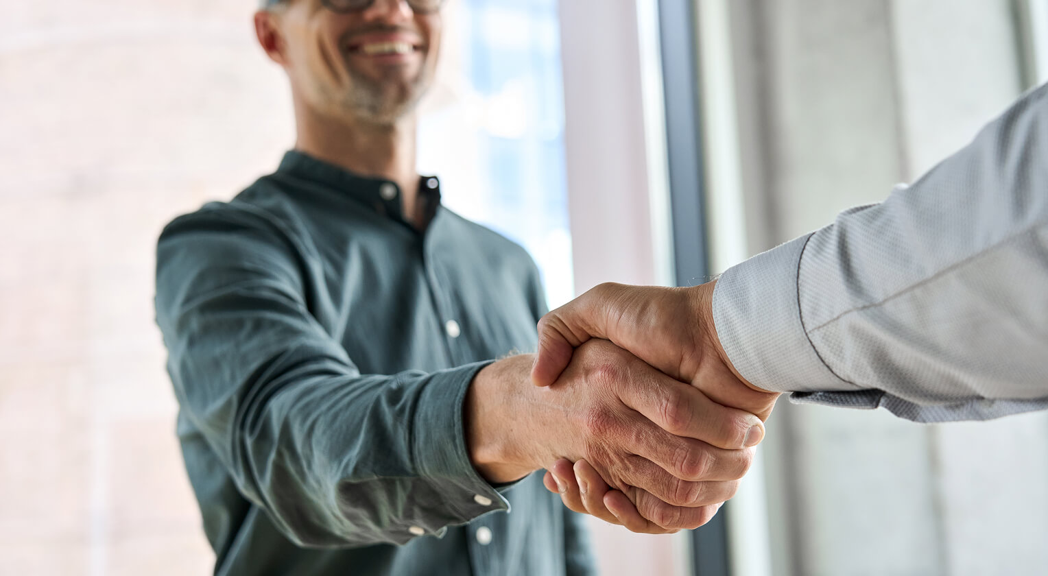 Two men shaking hands in a professional setting
