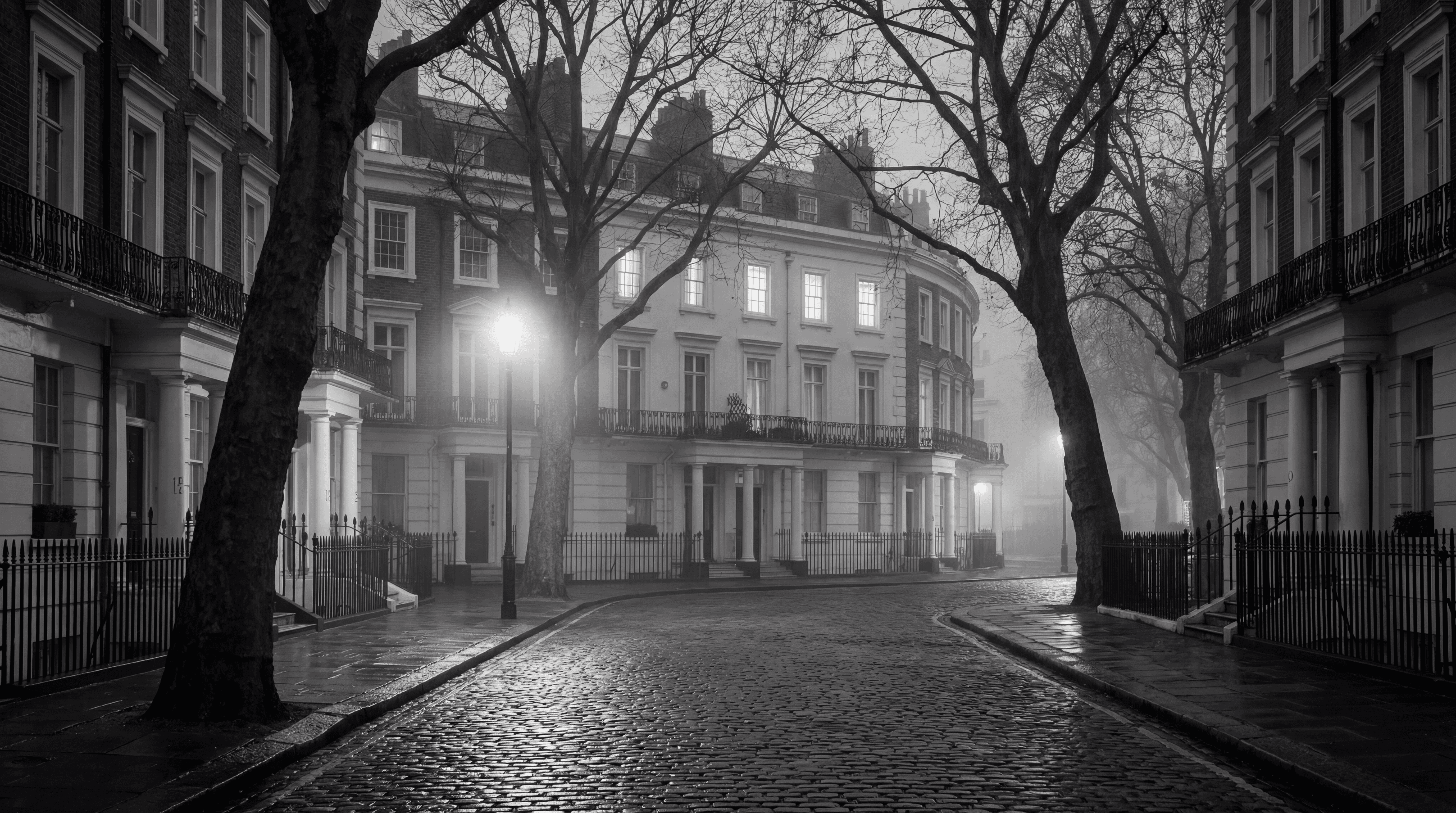 Empty Prime Central London residential street at dusk with stucco townhouses and warm window lights, illustrating the 2026 London property market correction, monochrome editorial photograph