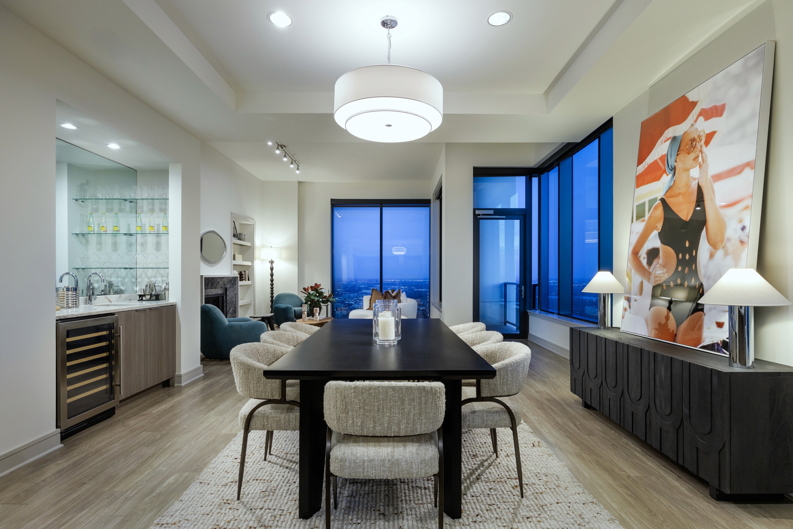 Modern dining room with city view and artwork.