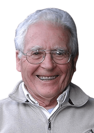 A cheerful portrait of an elderly man with white hair and glasses, smiling warmly while outdoors. Dressed in a casual zip-up sweater, he exudes a friendly, approachable demeanor, with greenery in the background adding a natural, relaxed setting to the image.