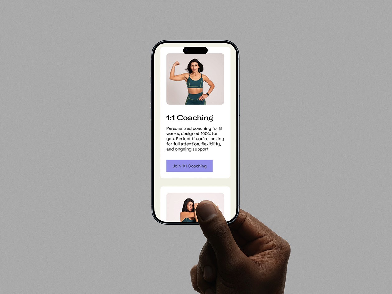 Close-up portrait of a person wearing a gray insulated hooded jacket with the hood up, showing their face framed by the hood against a light background.