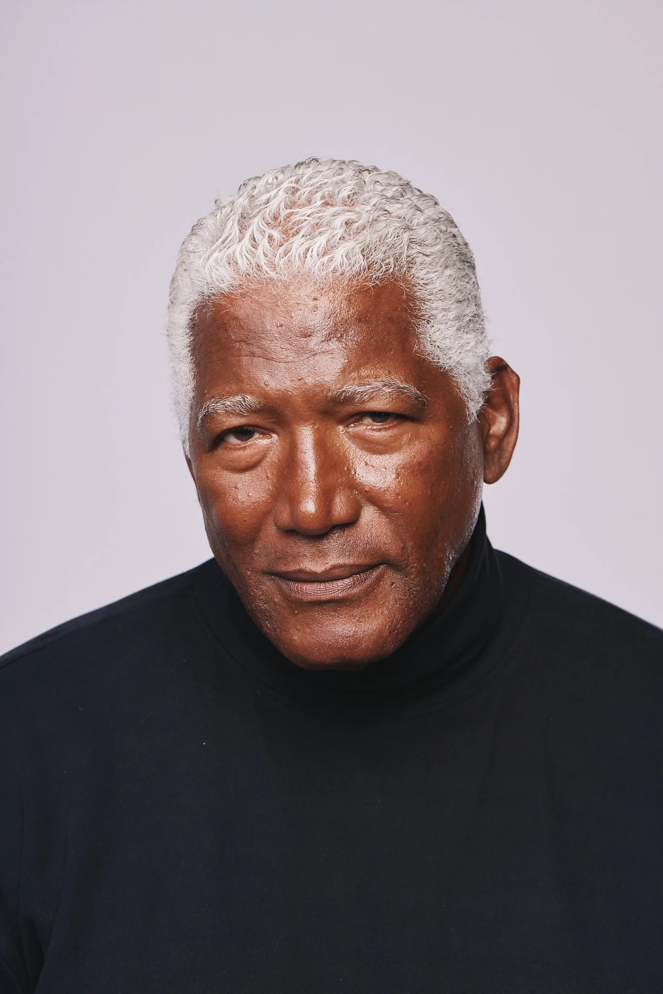 older man tilts head faint smile — portrait photography by Tom Kubik