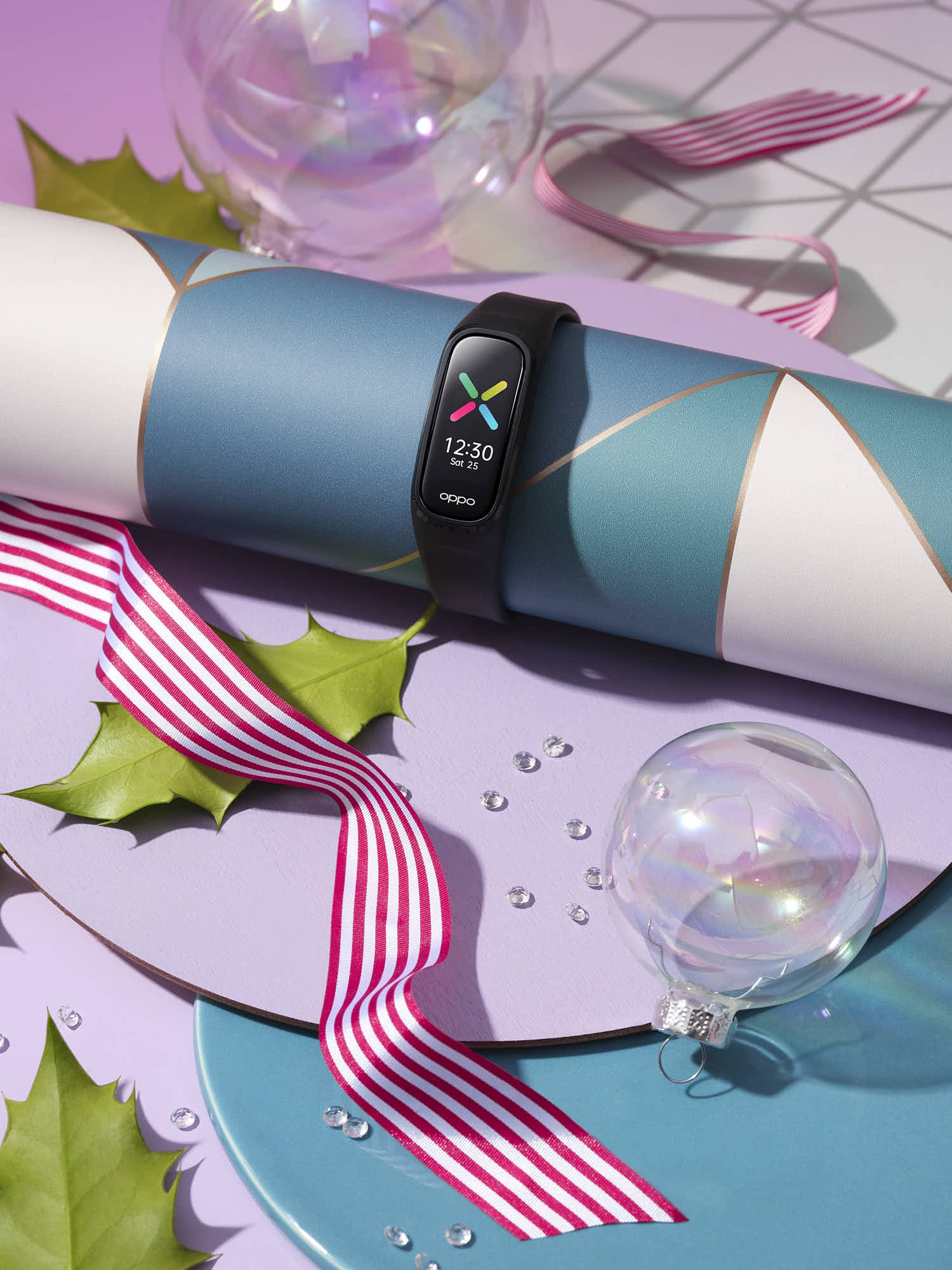 Smart fitness band with colorful display on festive background with ribbon and ornament.