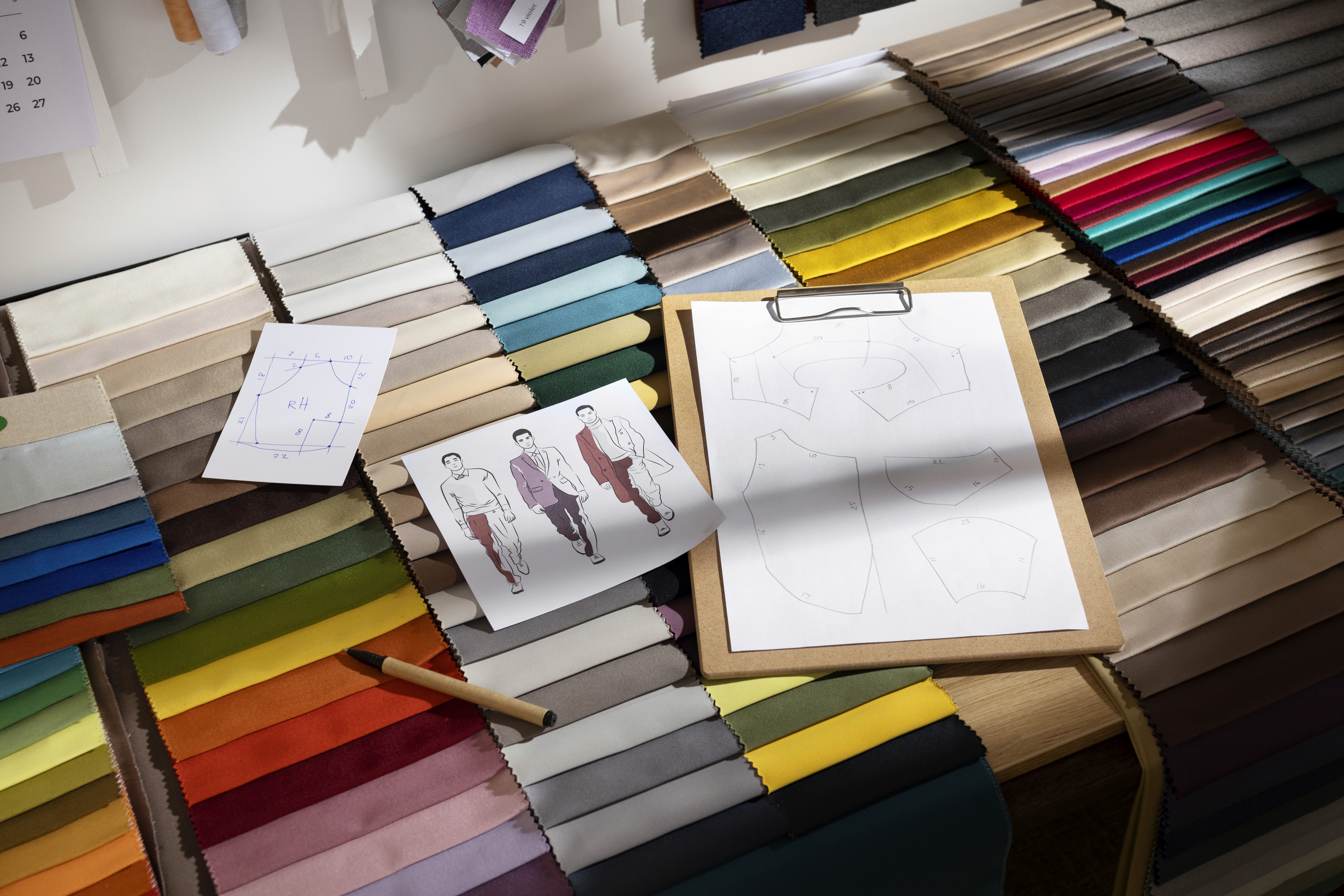 Bachelor of Design (B.Des) showcasing fabric swatches, fashion sketches, and design patterns representing creative design education.