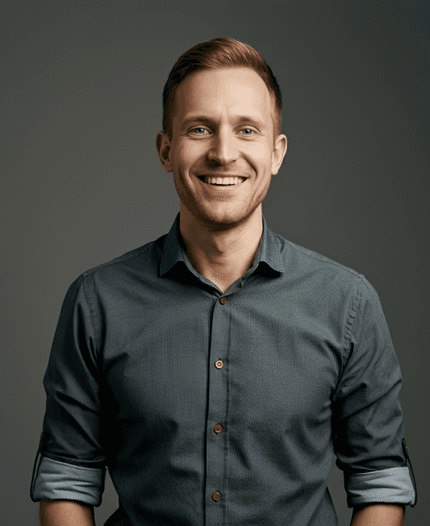 A smiling man wearing a gray shirt poses for the photo.