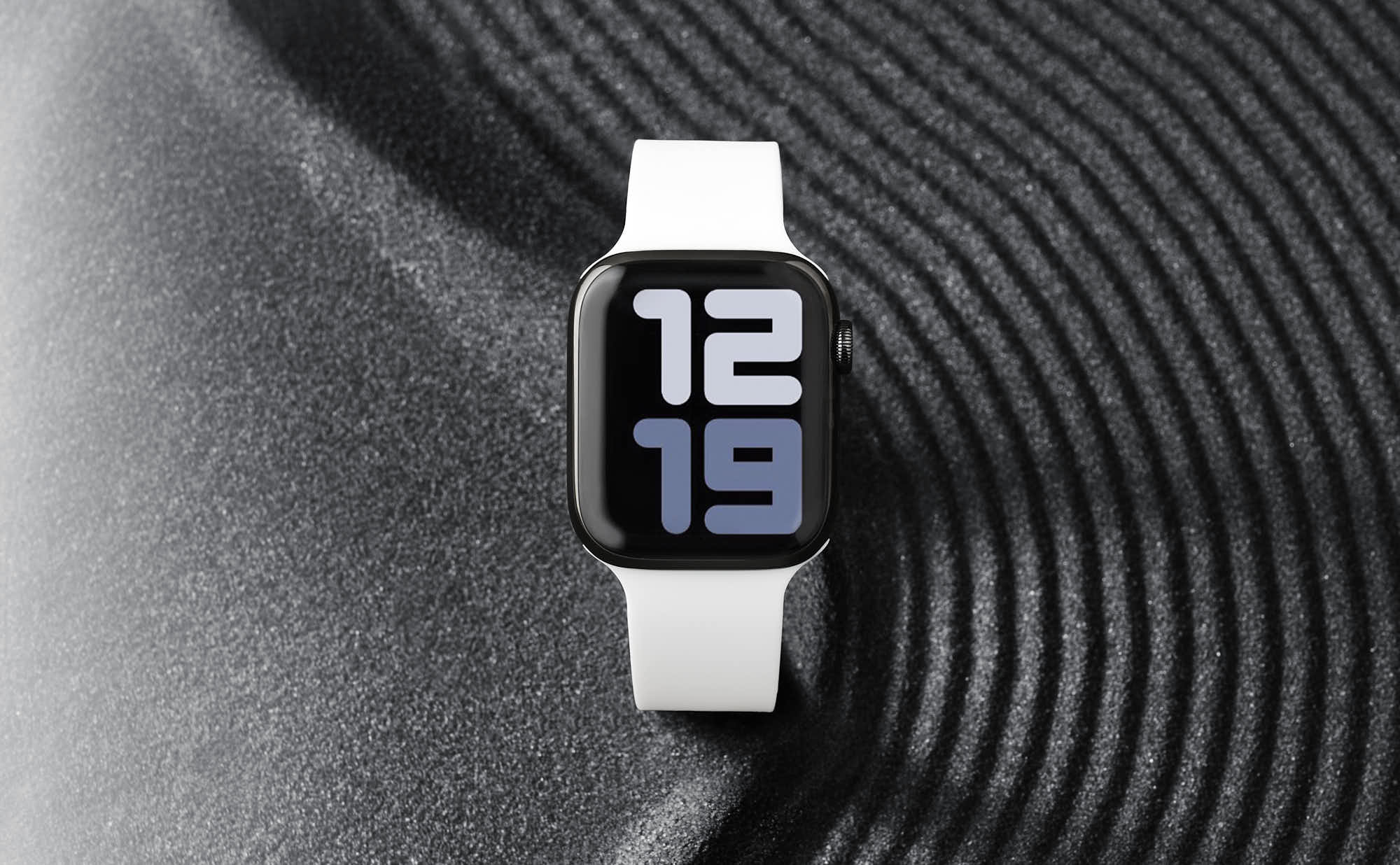 A smartwatch with a black and silver design, displaying the time and fitness metrics on a textured surface.