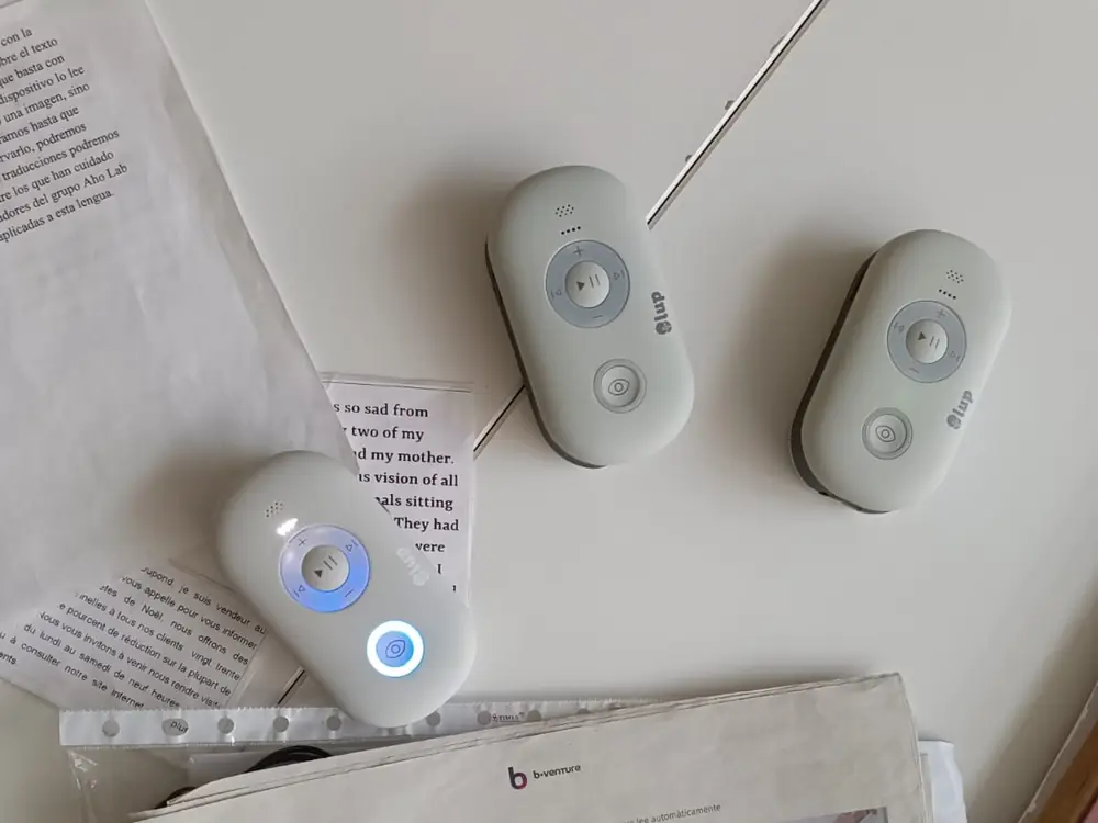 Tres Lupas Inteligentes de LUP sobre una mesa, junto a textos impresos en castellano, inglés y francés