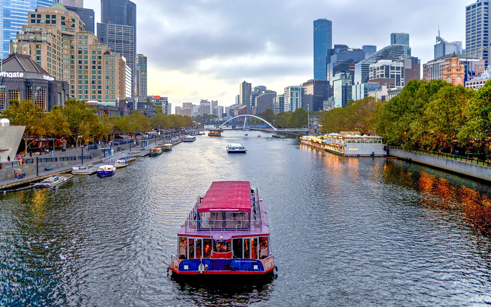 Dinner cruise boat on Yarra River with Melbourne skyline in the background.