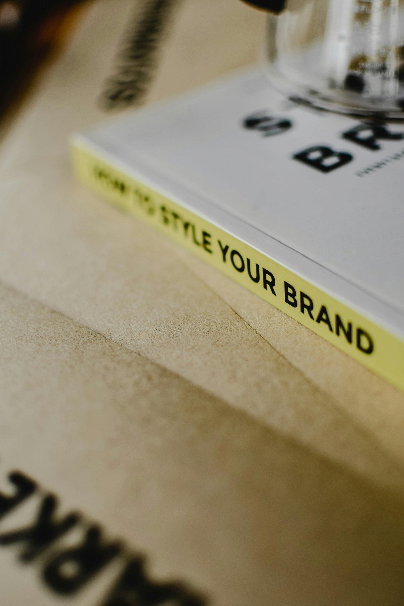 A close-up of a book cover with a bright yellow spine and text, partly obscured by a cloth background.