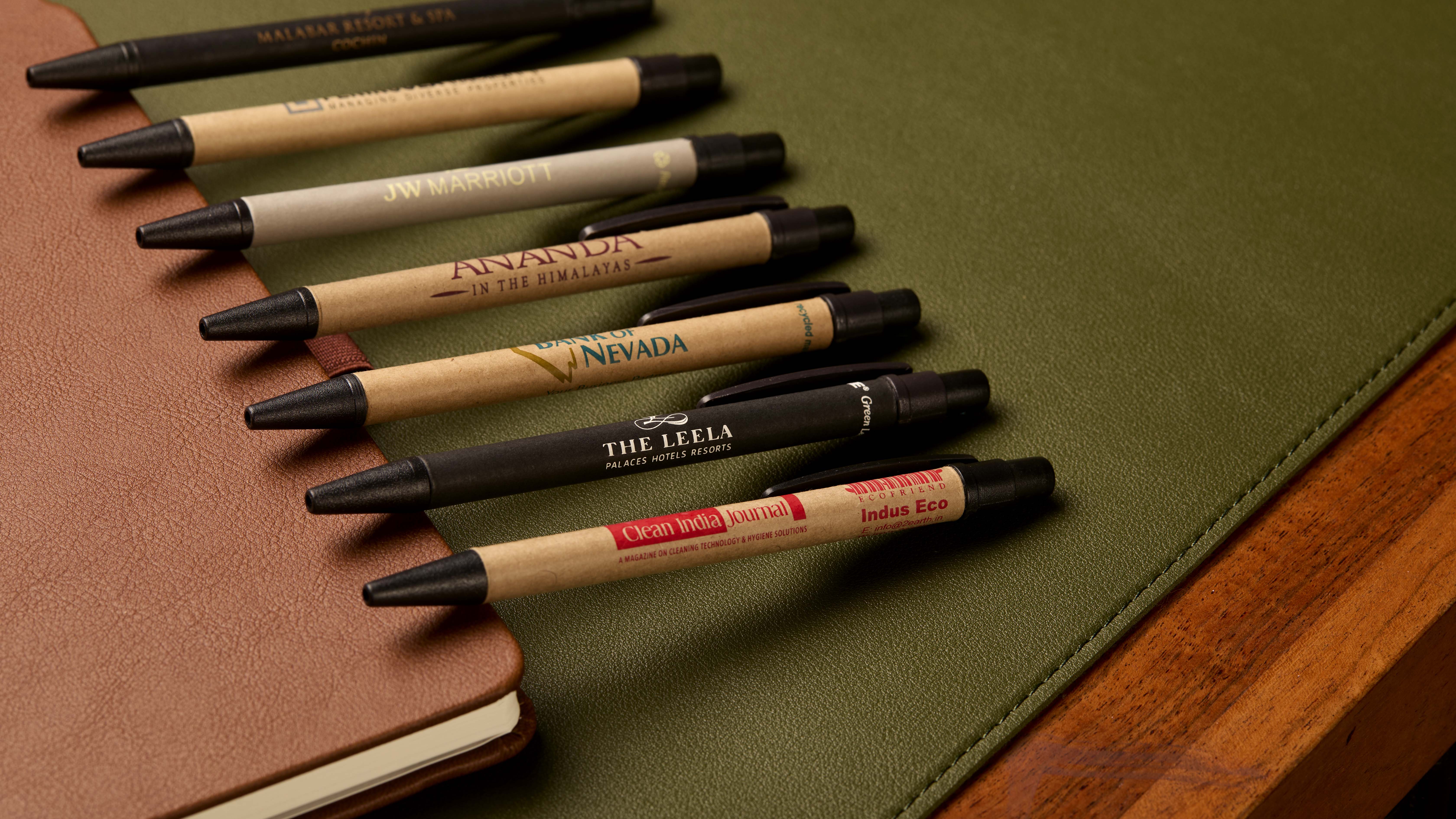 A smiling young man with crossed arms, wearing a plaid shirt and white t-shirt, poses against a dark background.