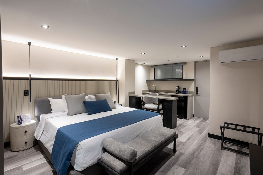 Hotel residencial premium Medellín, suite Altus Comfort con cocina privada, barra americana y vestier para máxima comodidad en estadías prolongadas.