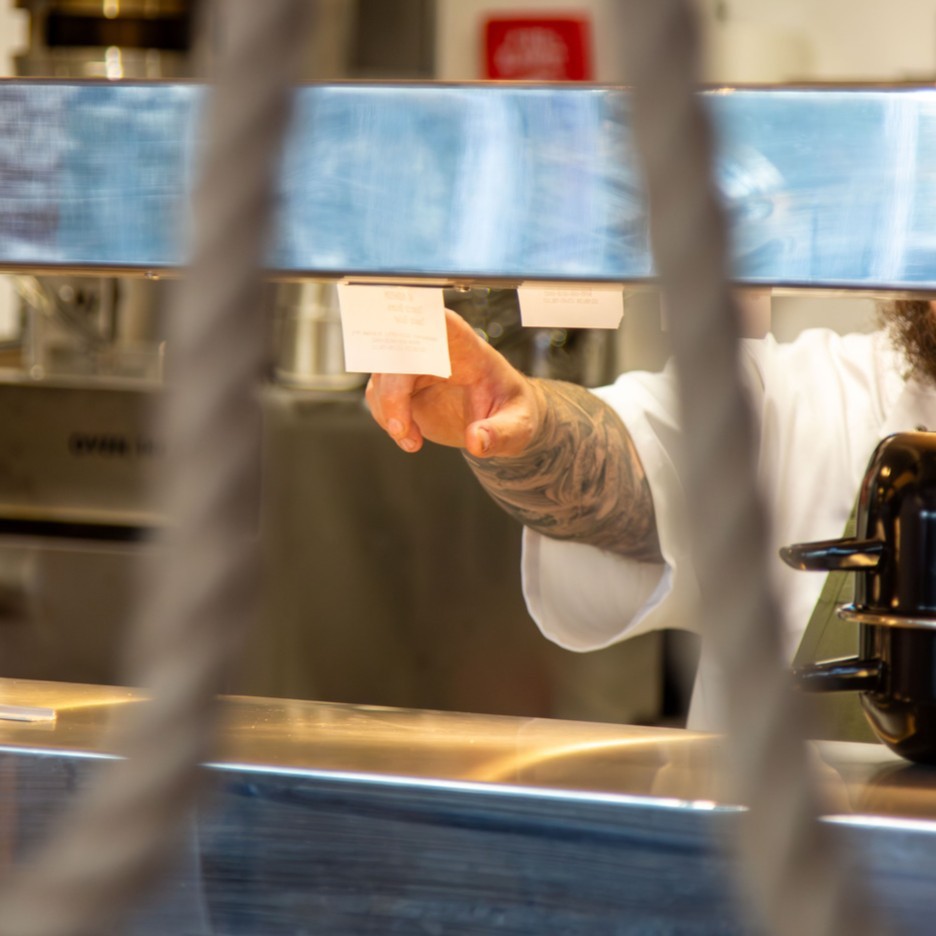 A chef checking a ticket in a commercial kitchen