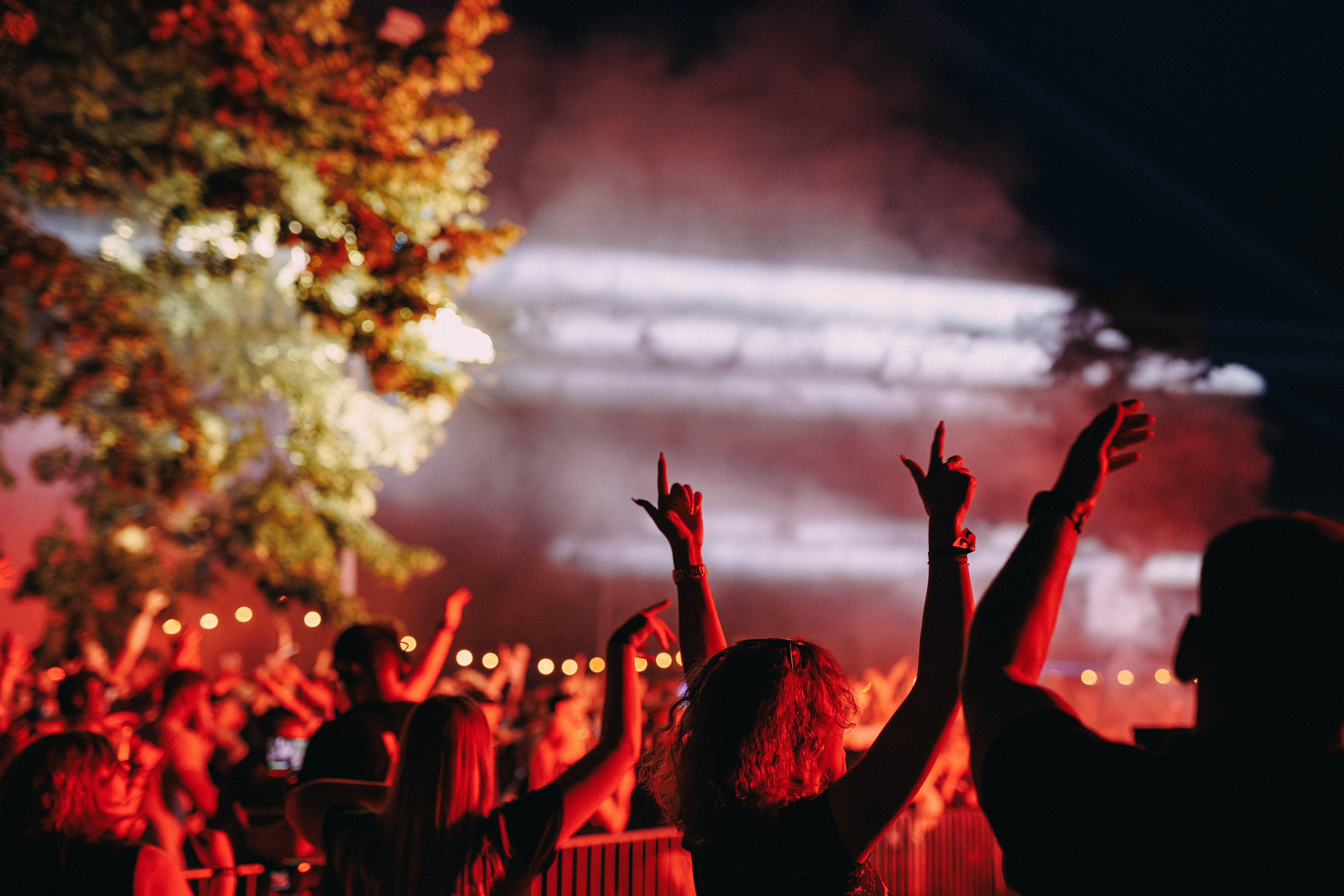 Three women holding hands at outdoor event