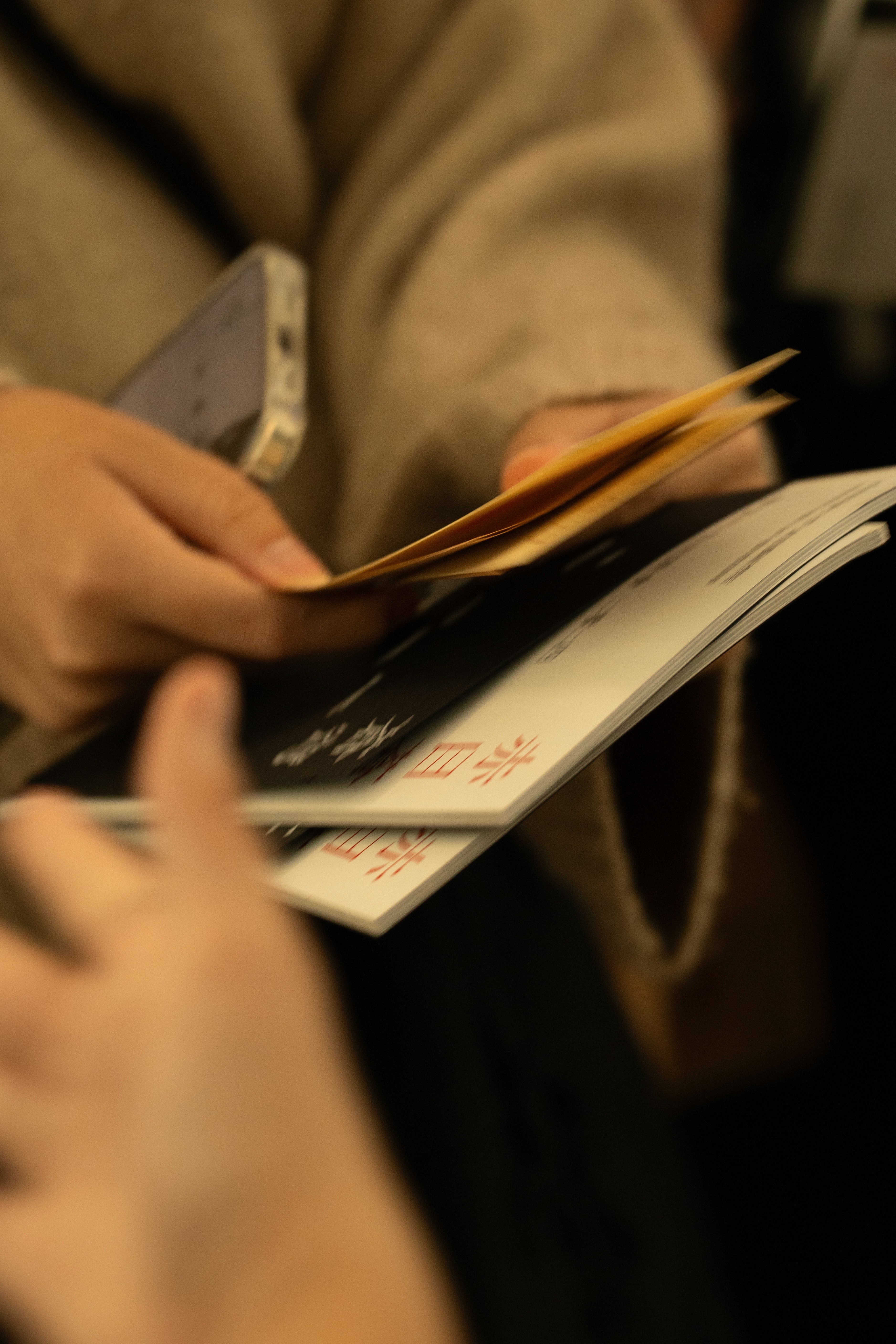 audience holding the festival program and the merch with different film sections