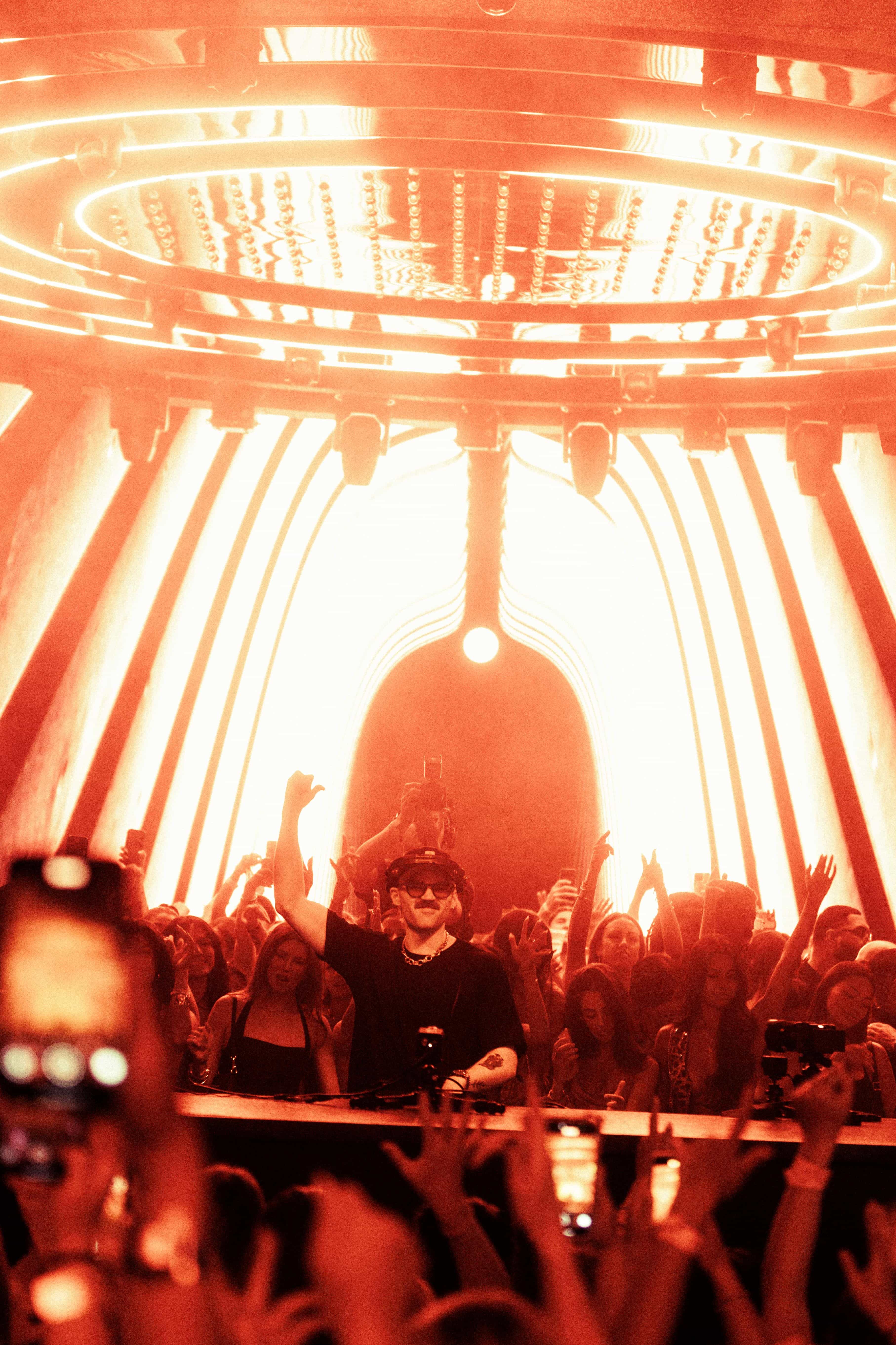 Dom Dolla performing at LIV Las Vegas nightclub with immersive red lighting and a packed crowd, captured by A World Away
