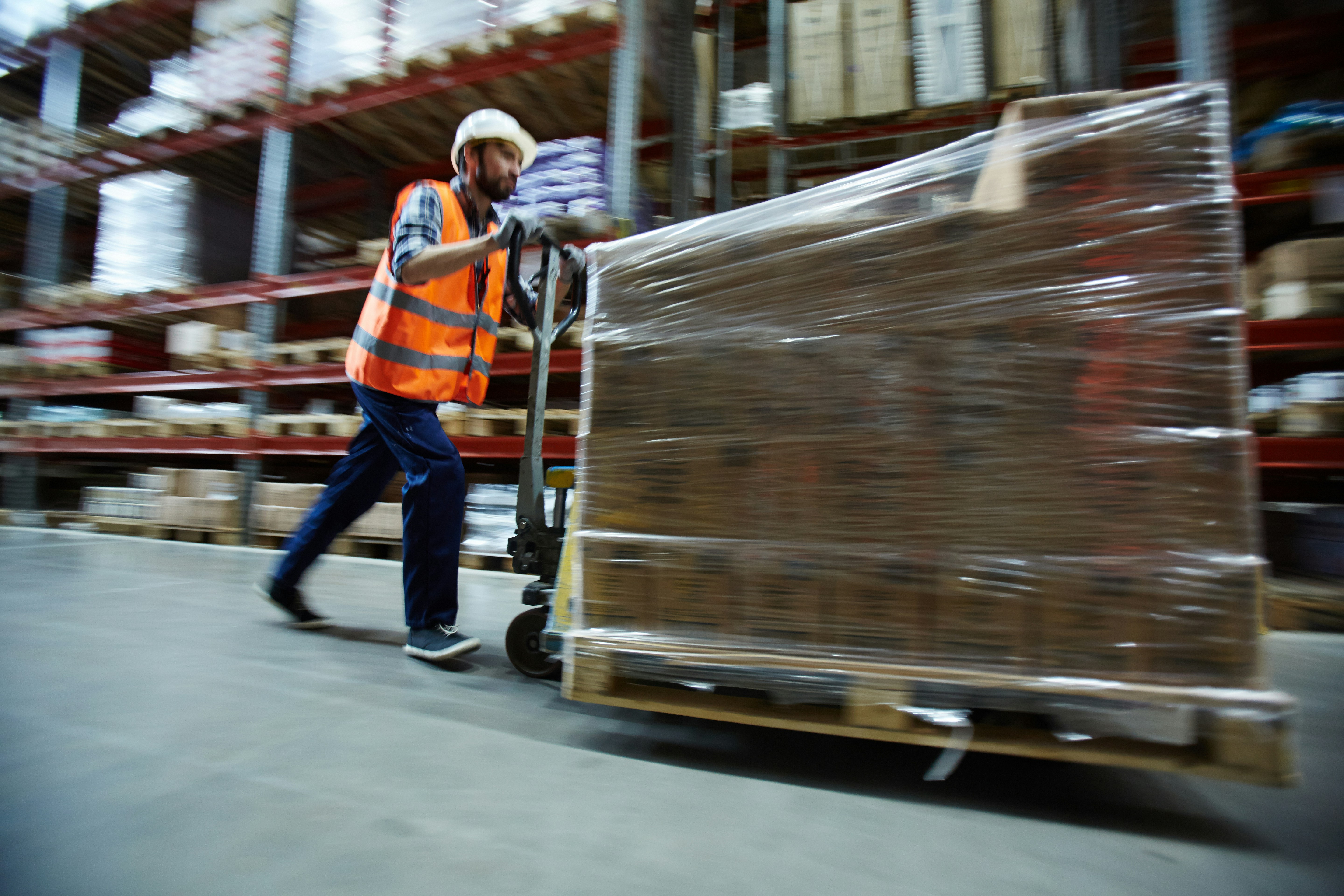 man with pallet truck walking through 3PL warehouse