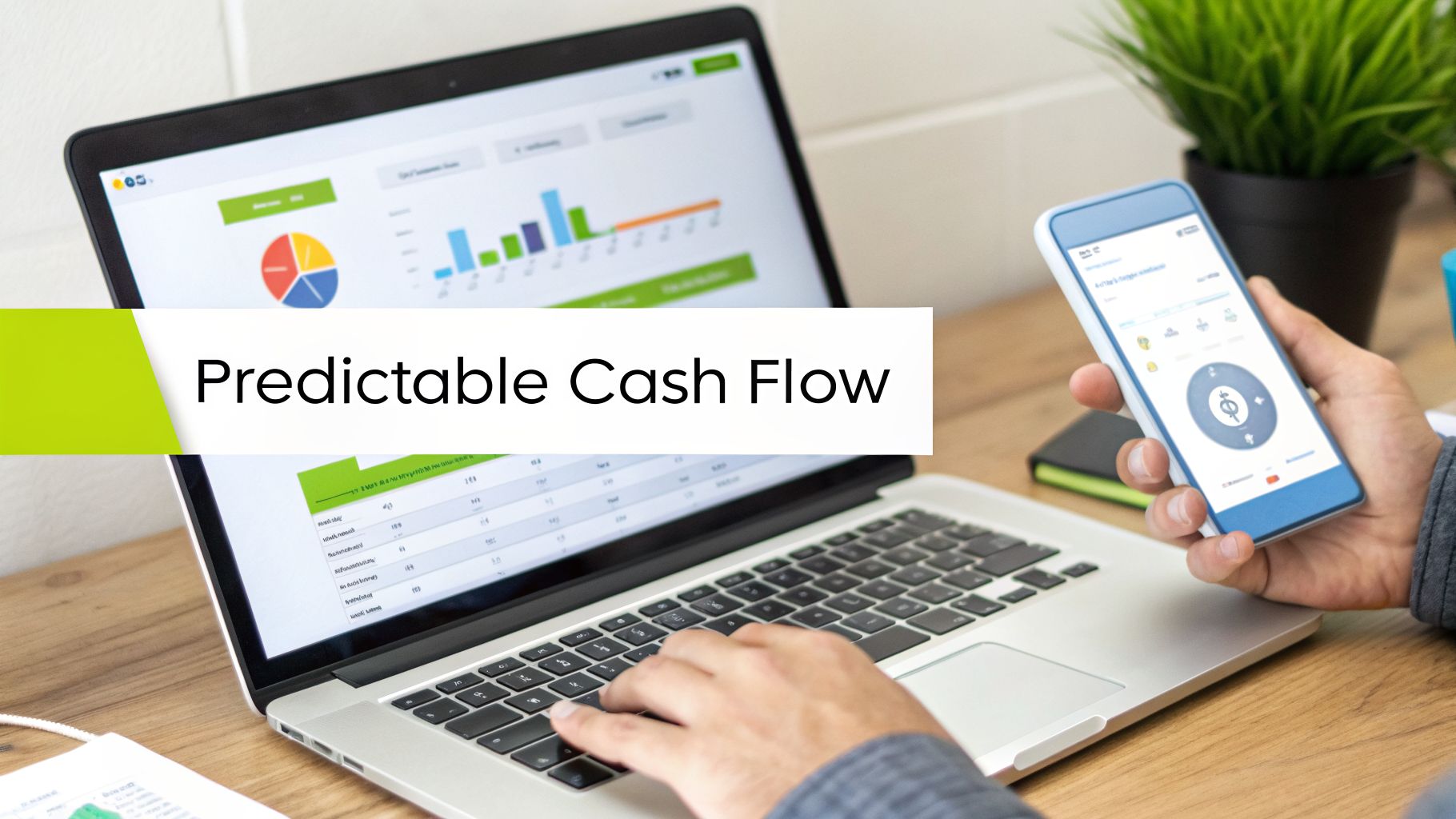 Person managing finances on a laptop with charts and a smartphone, highlighting predictable cash flow.