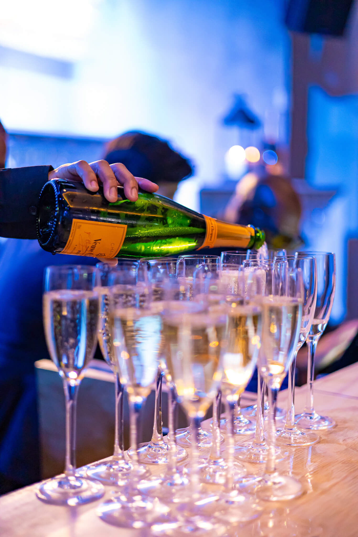 Champagne being poured into glasses during an evening event reception
